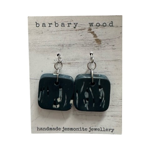 Blue square drop earrings with a black and white abstract design and silver earring hooks.