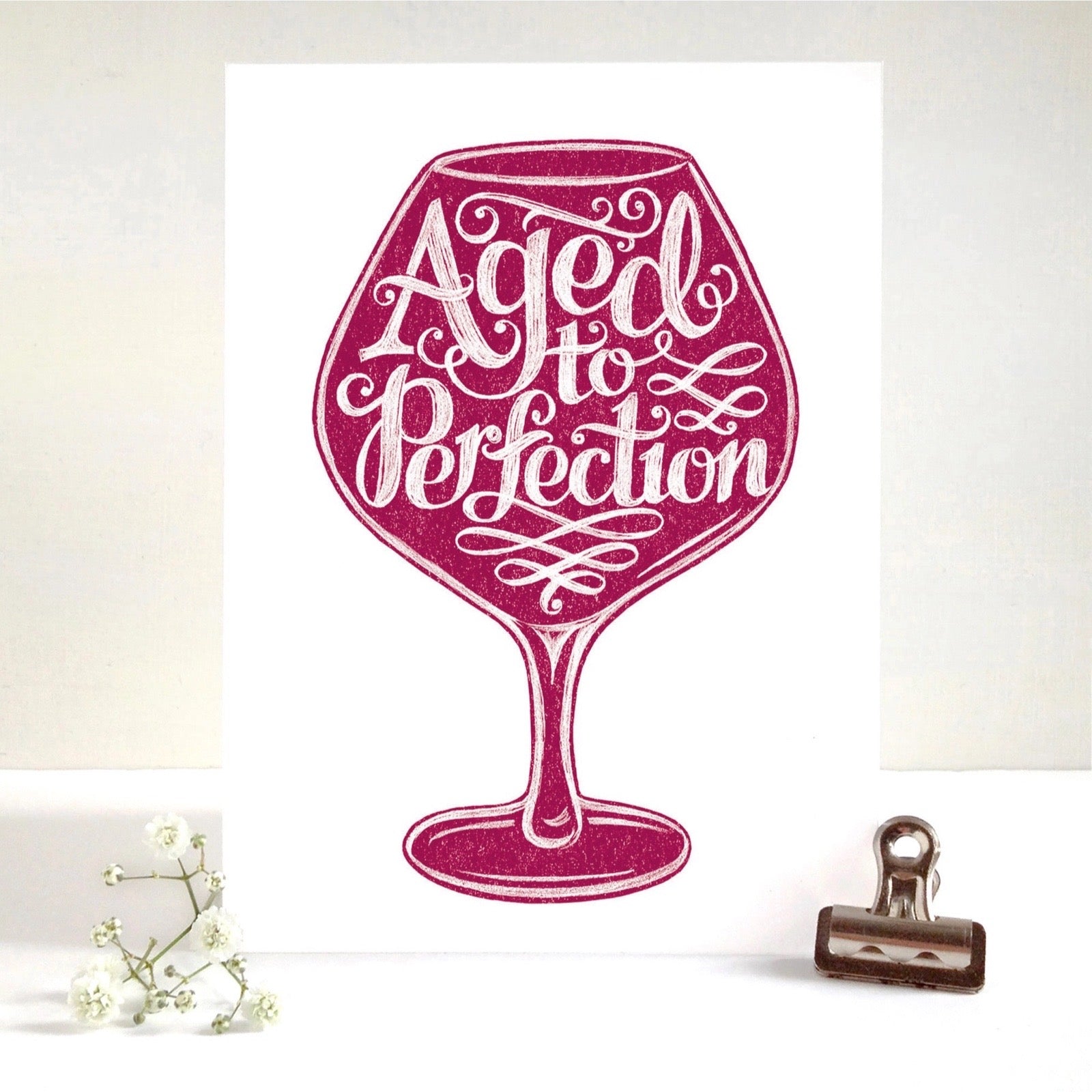 Wine glass with 'Aged to Perfection' text on a white background.