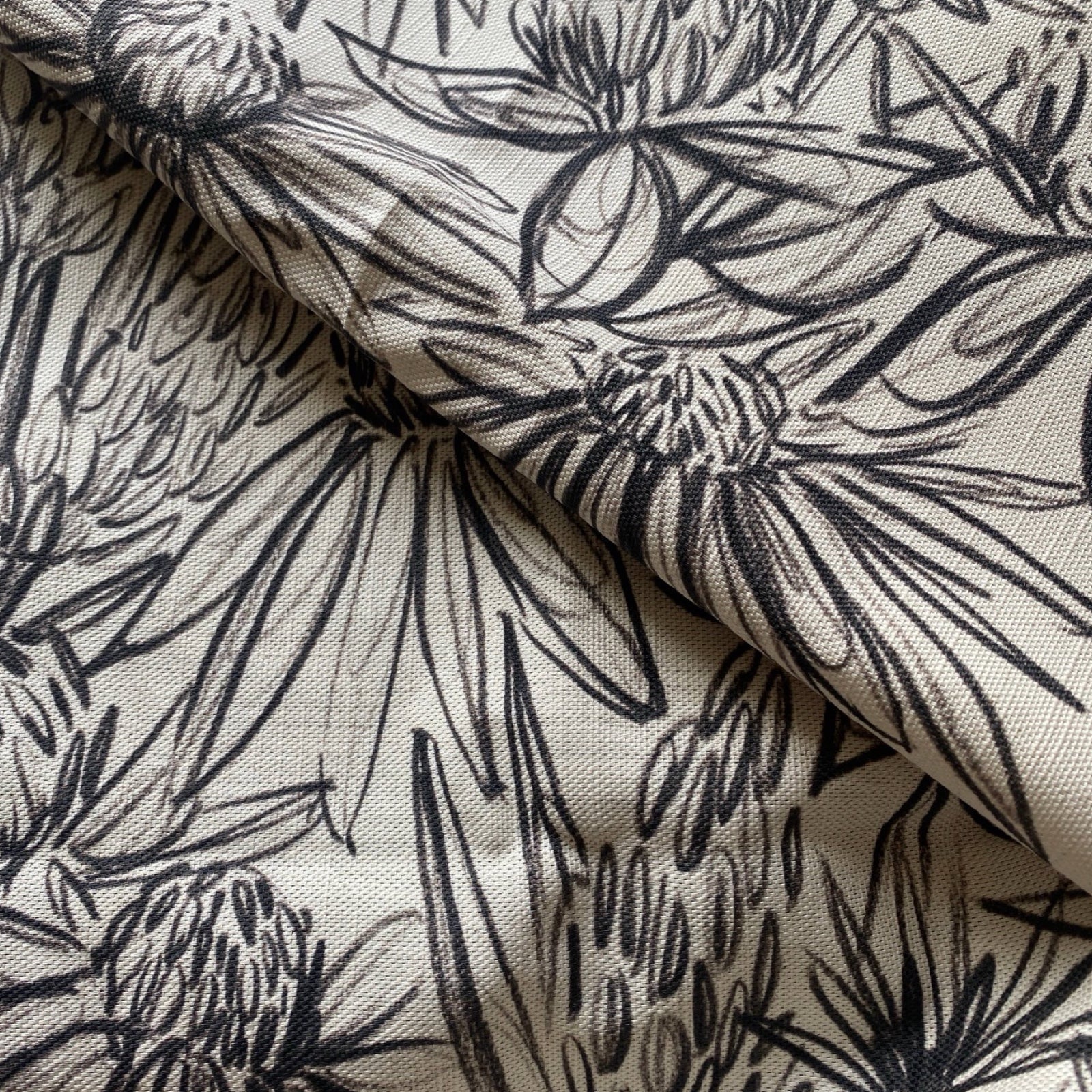 Cream coloured fabric with a black ink design.
