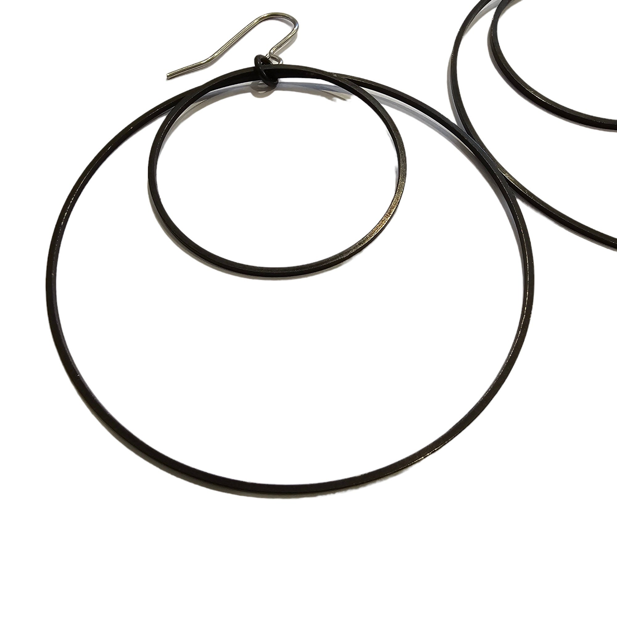 A close up of a circular hooped earring against a white background.