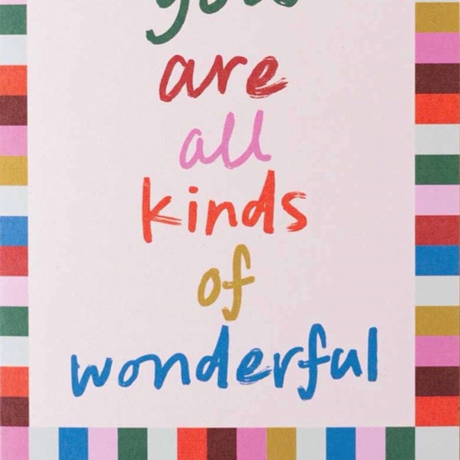 A card with the hand-lettered quote 'you are all kinds of wonderful' in multicolour text on a pale pink background, framed by multicoloured vertical stripes on the left and right borders.