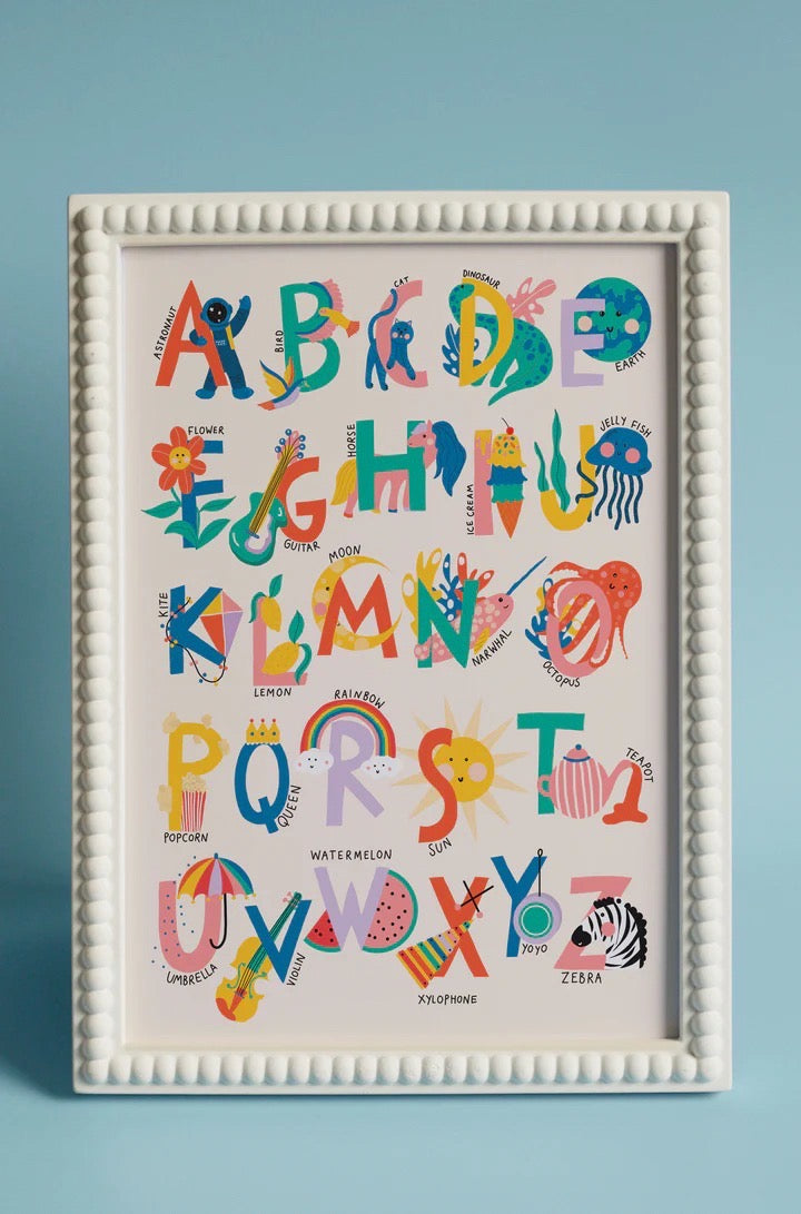 Framed colourful alphabet print on a blue background.