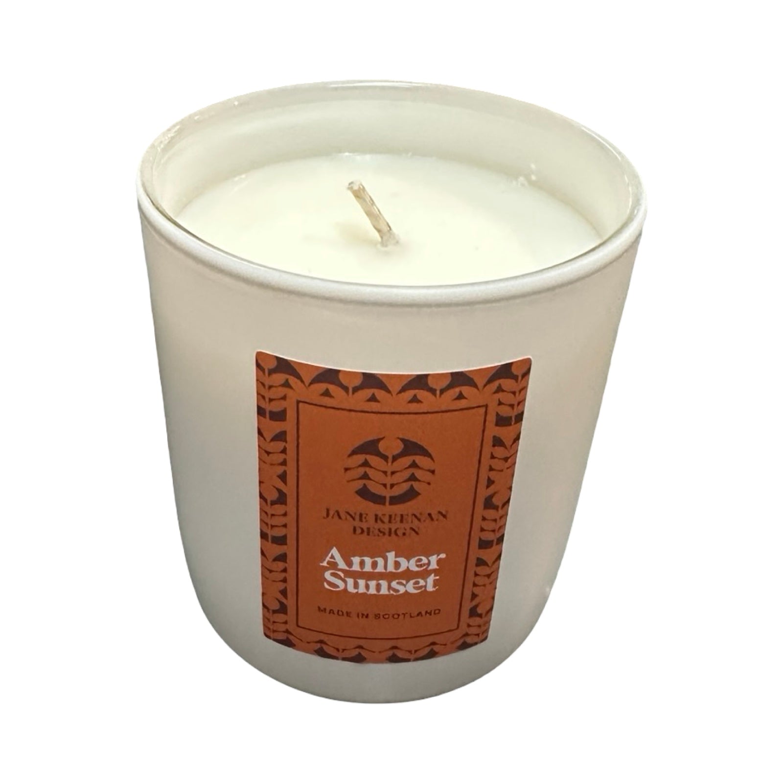 Candle in a white container with an amber sunset label on a white background.