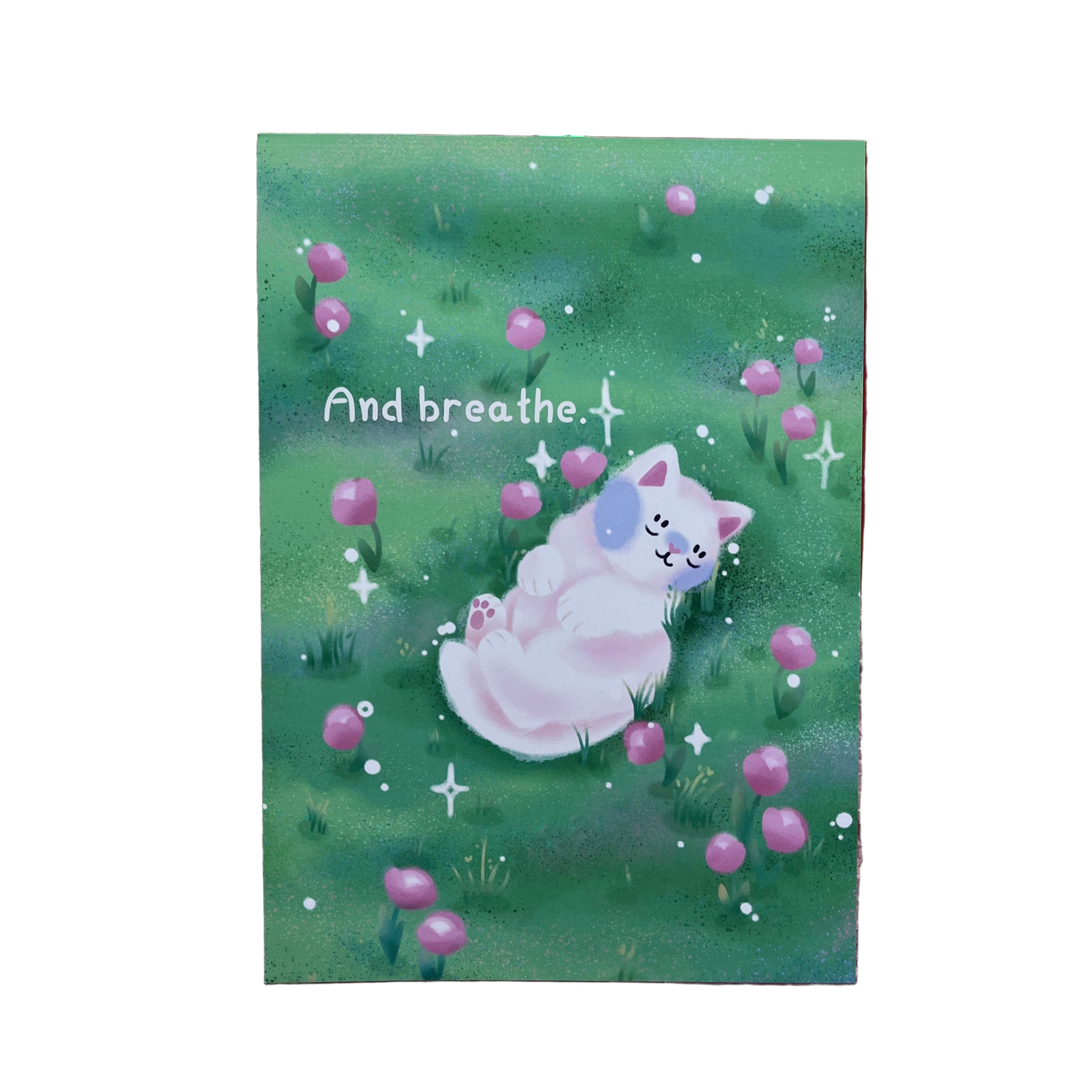 Art print of a white cat sleeping amongst pink tulips in a field. The text reads 'And breathe'.