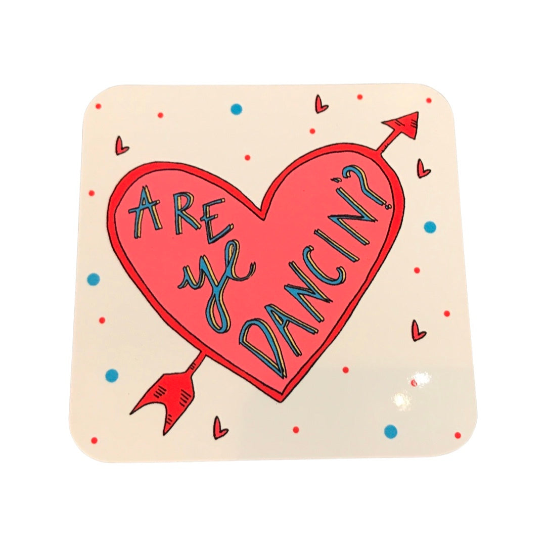 Drinks coaster featuring a red heart with an arrow through it and the text 'Are ye Dancin?' taken from the popular old Glasgow saying 'Are you dancing? Are you asking? I'm asking, then I'm dancing!'