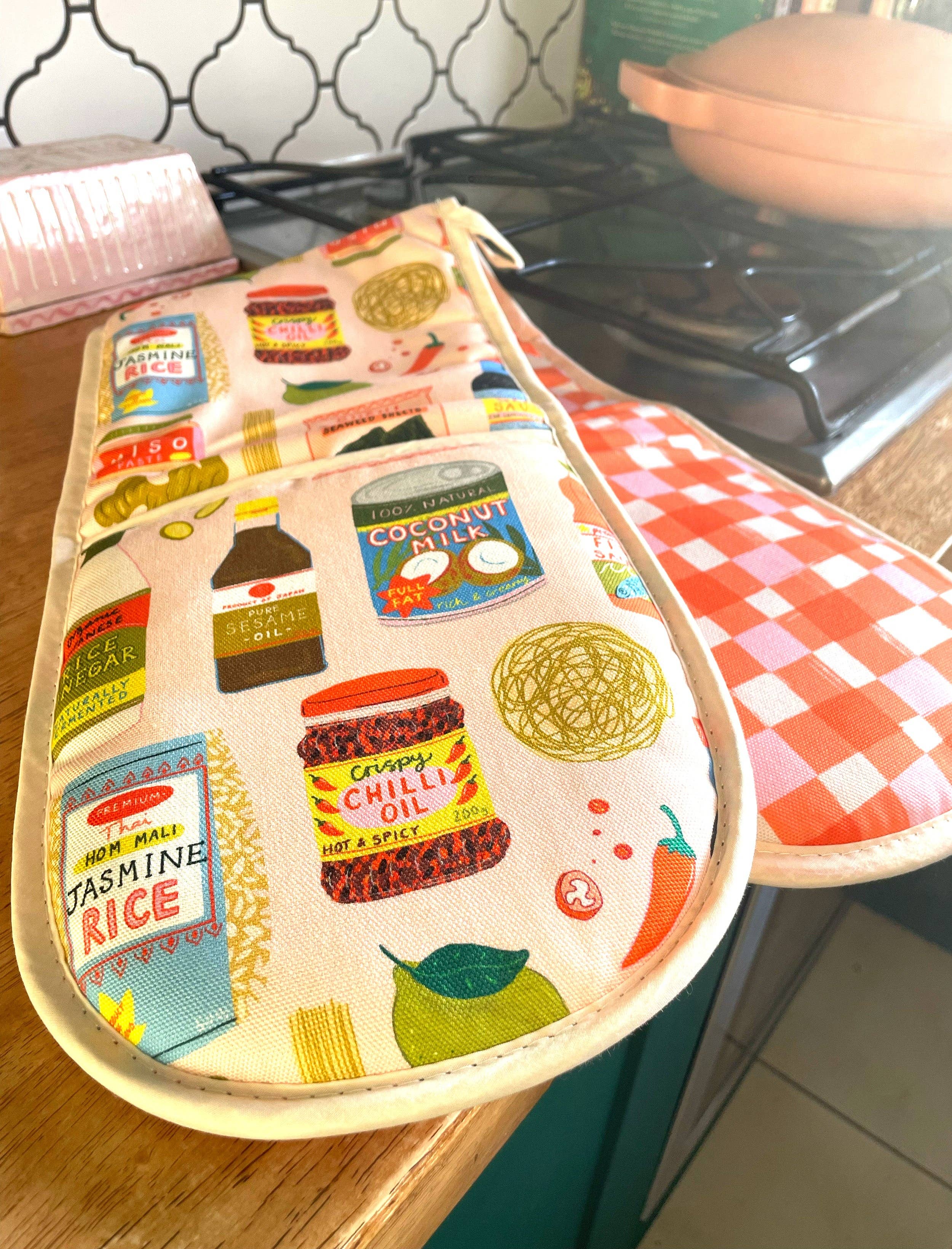 Oven mitt with food-themed design on a kitchen counter.