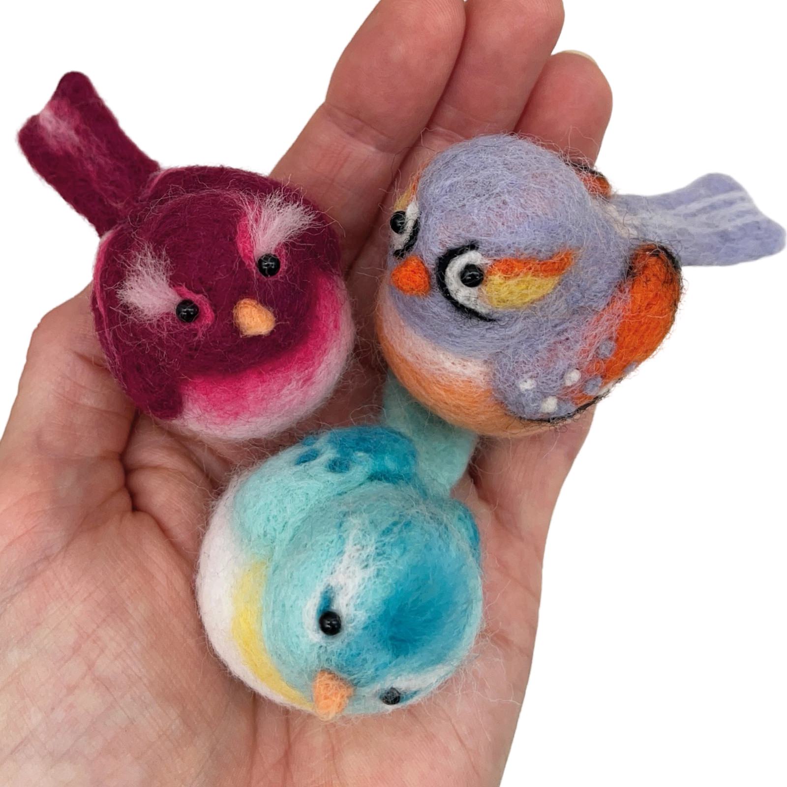 3 felted baby birds, 1 blue, 1 red and 1 orange sitting in someone's hand.