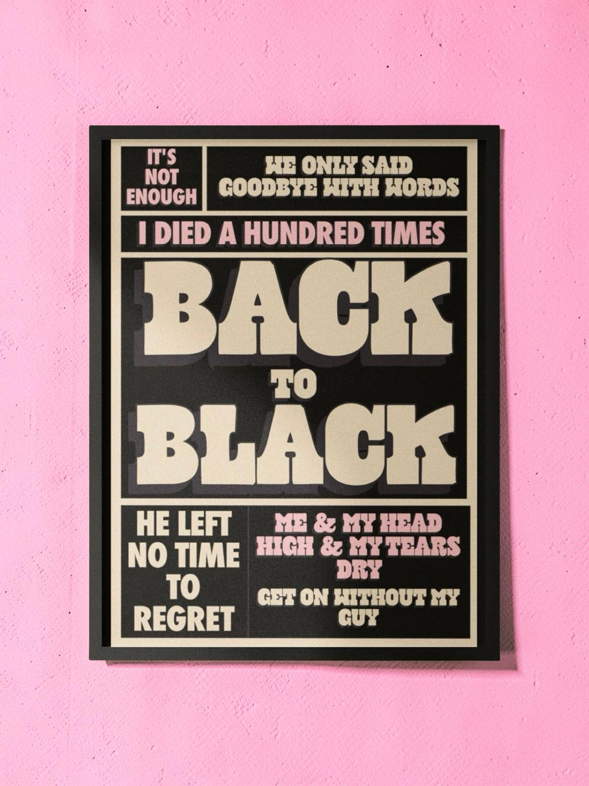 Framed poster with text on a pink wall.