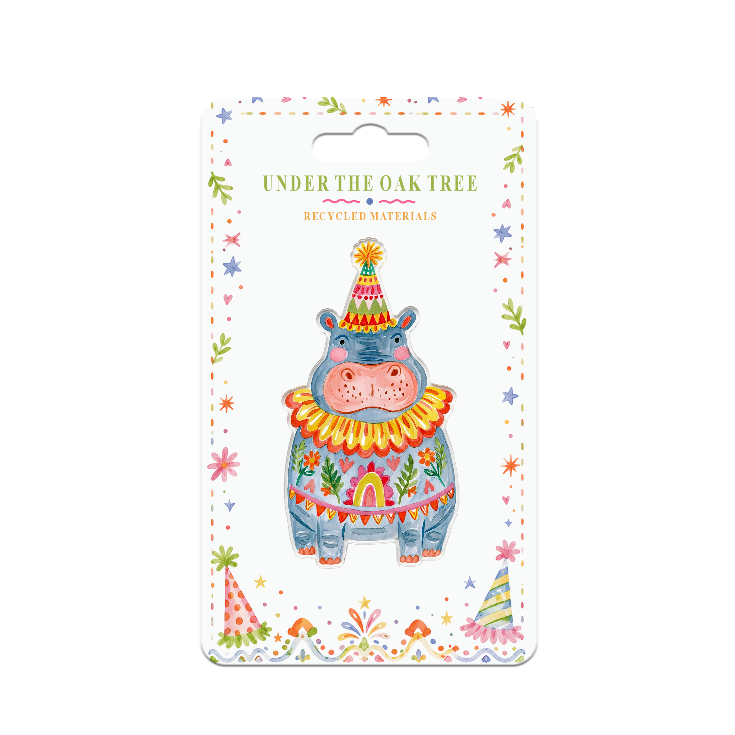 A packaged decorative card featuring a colorful illustrated hippo wearing a party hat and patterned outfit, with the text 'UNDER THE OAK TREE' and 'RECYCLED MATERIALS' on a white background.