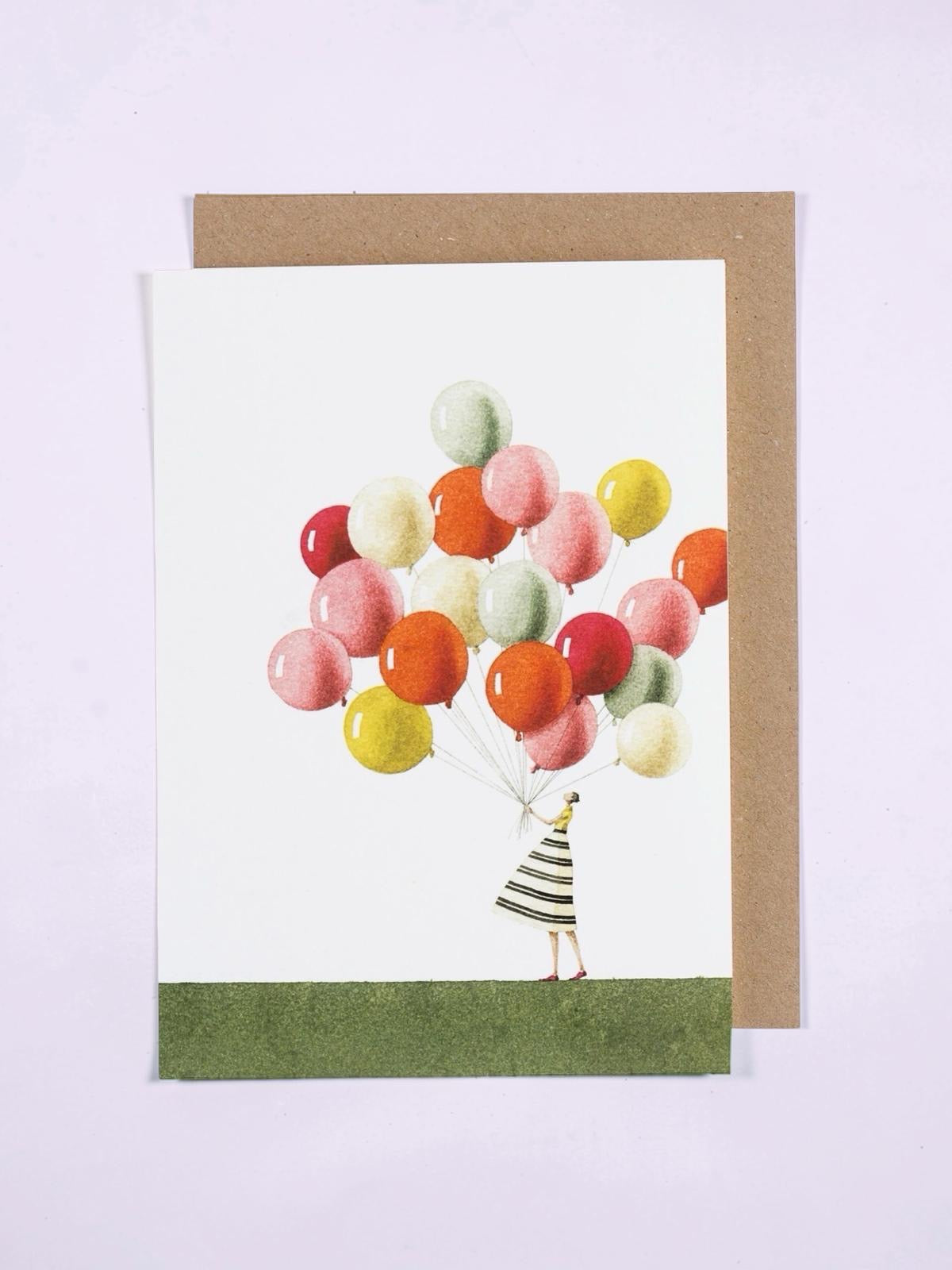 Greeting card with a person holding colourful balloons on a white background.