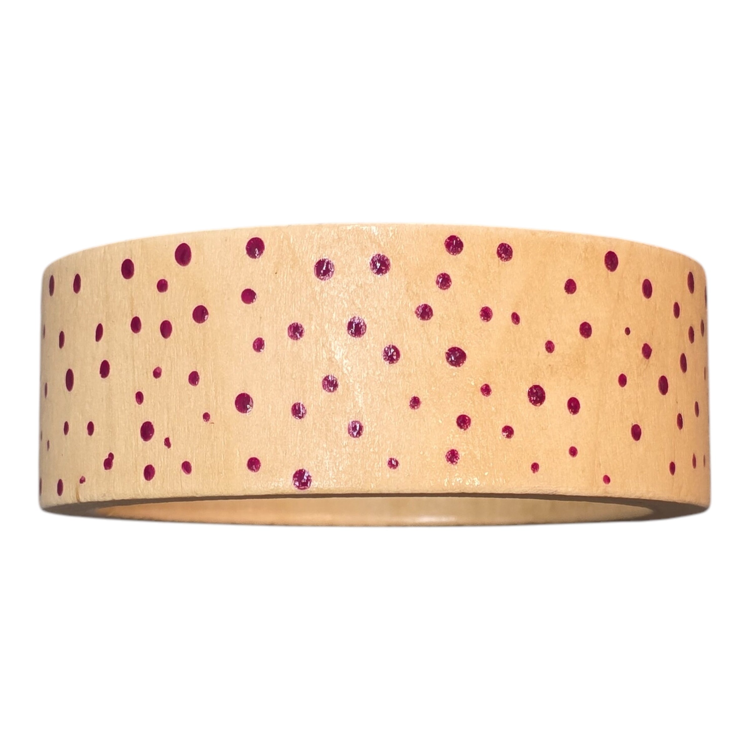 A bamboo wooden bangle with pink spots.