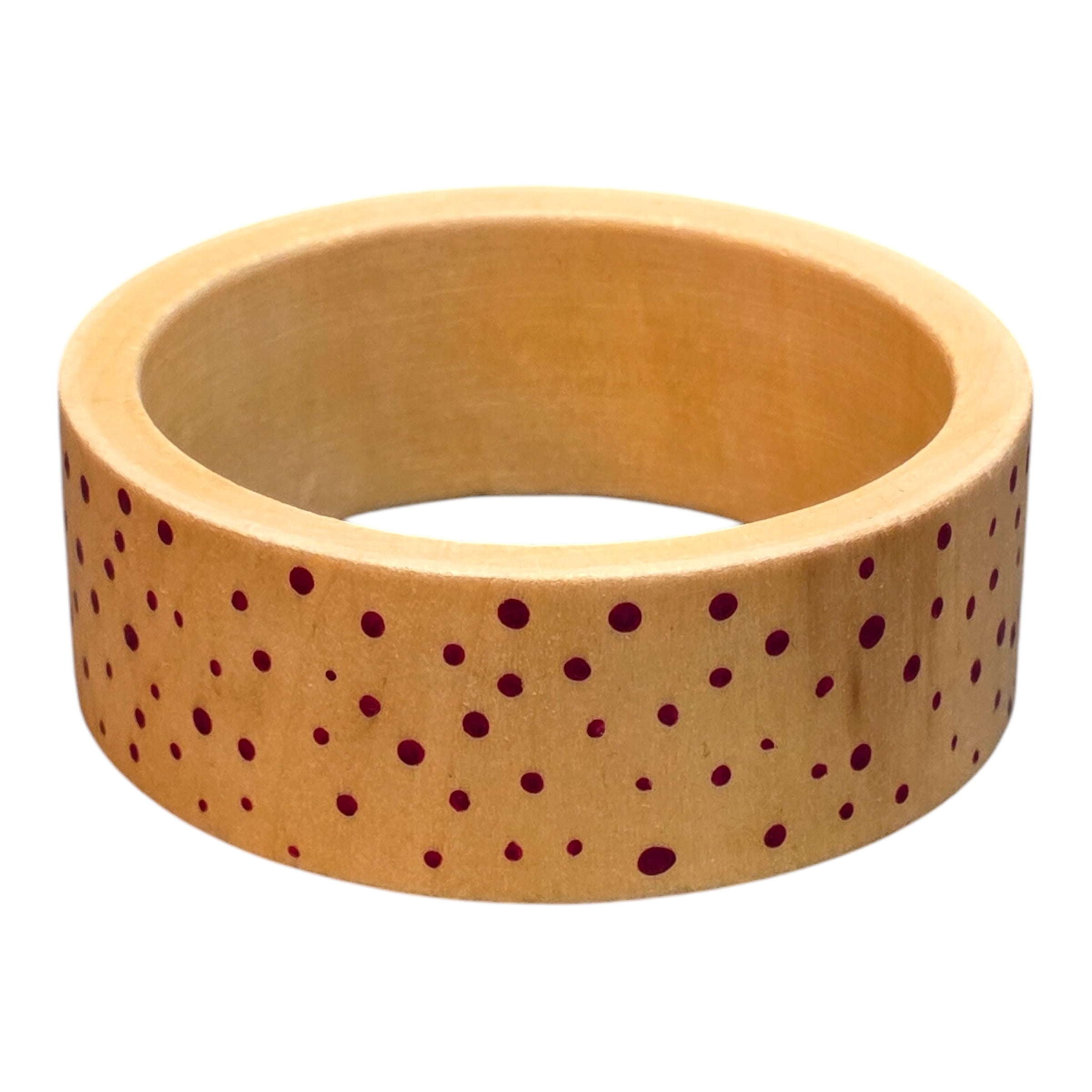 A bamboo wooden bangle with pink spots.