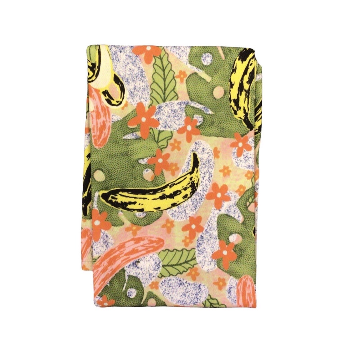 Banana tea towel features a fun illustration of bananas on green leaves with orange flowers. 