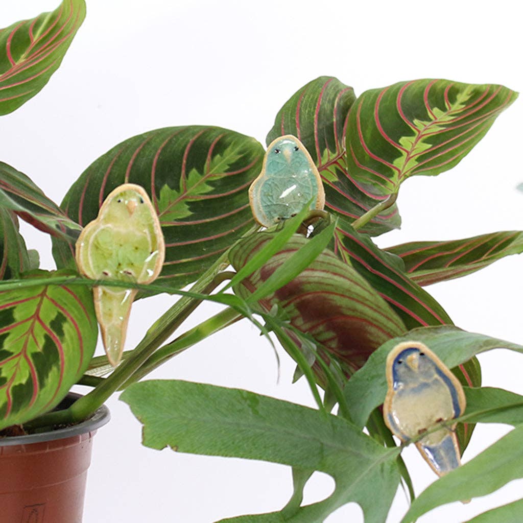 Blue plant hugger decoration handmade using British clay and recycled glass, sitting on plants.