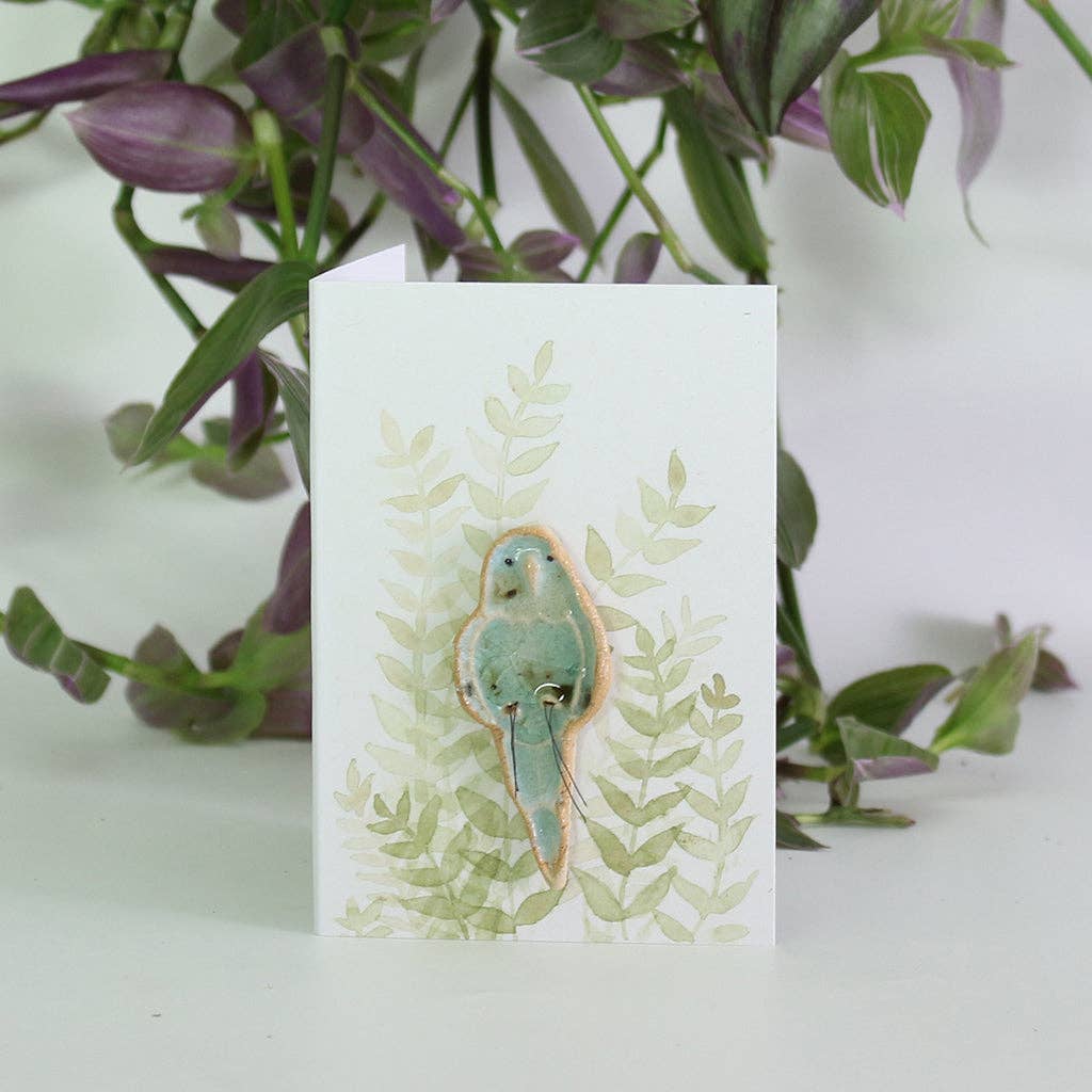 Blue plant hugger decoration handmade using British clay and recycled glass, on backing card.