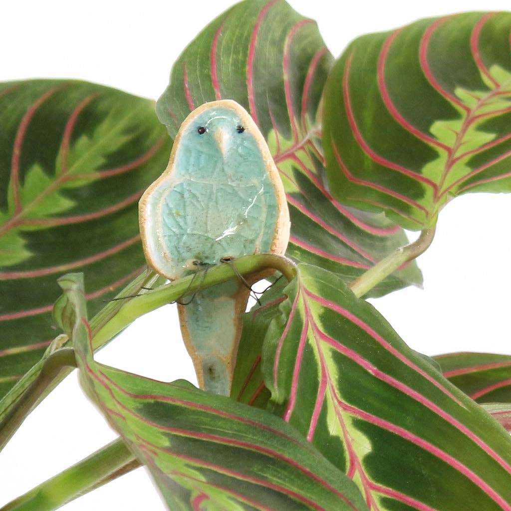 Blue plant hugger decoration handmade using British clay and recycled glass, sitting on plants.