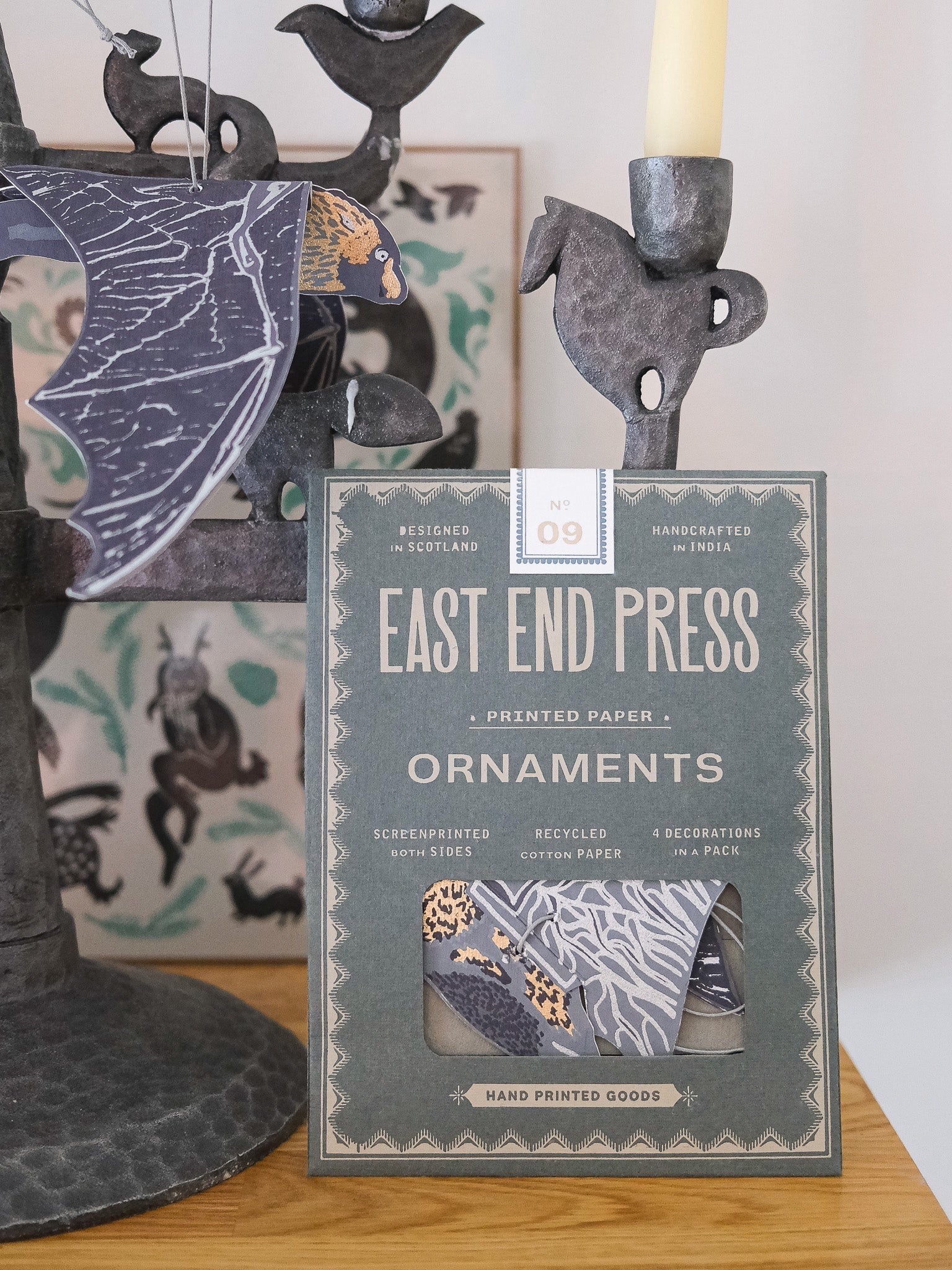Packet of East End Press bat ornaments with decorative items in the background.