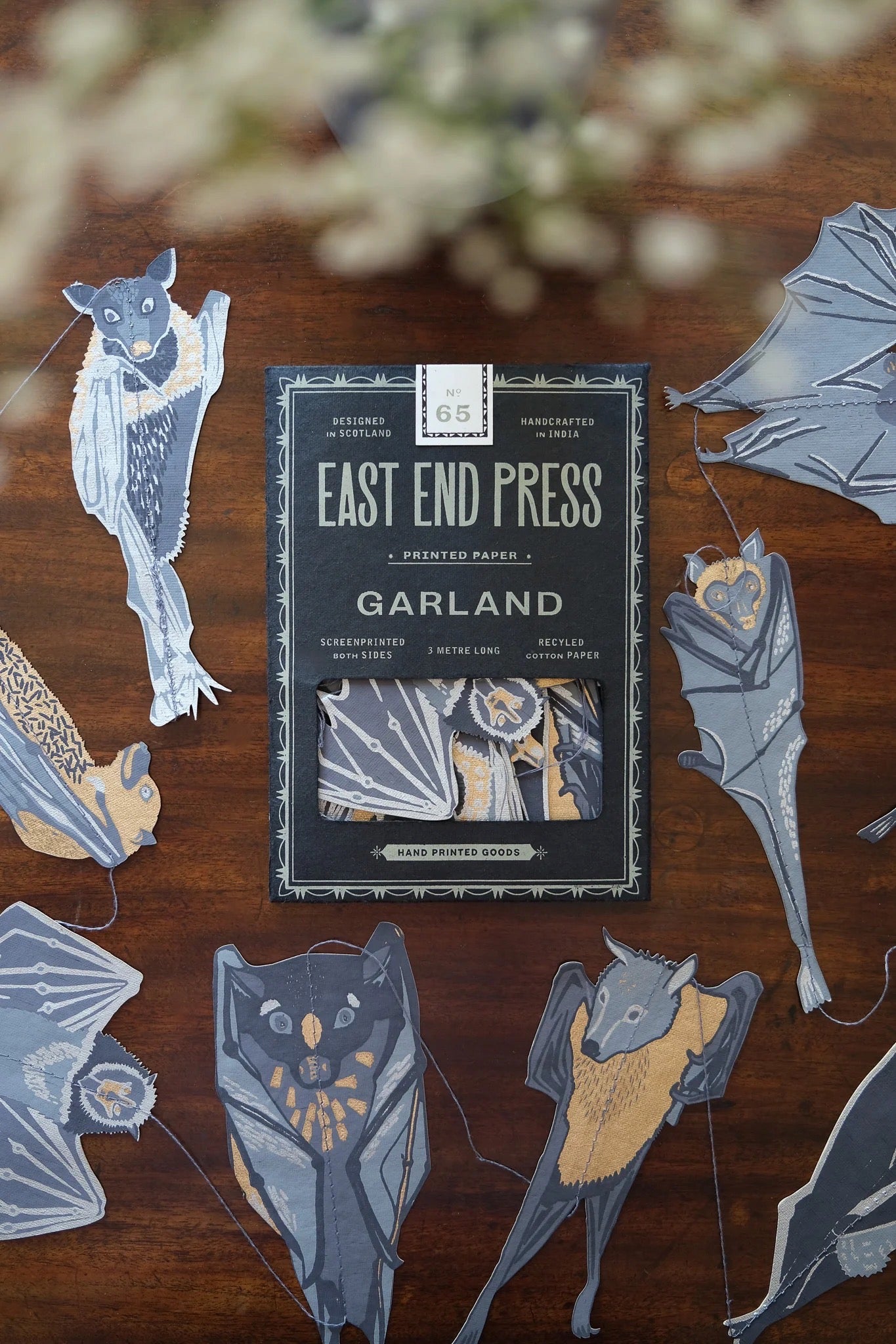 Pack of bats garland by East End Press on a wooden surface with decorative cutouts.