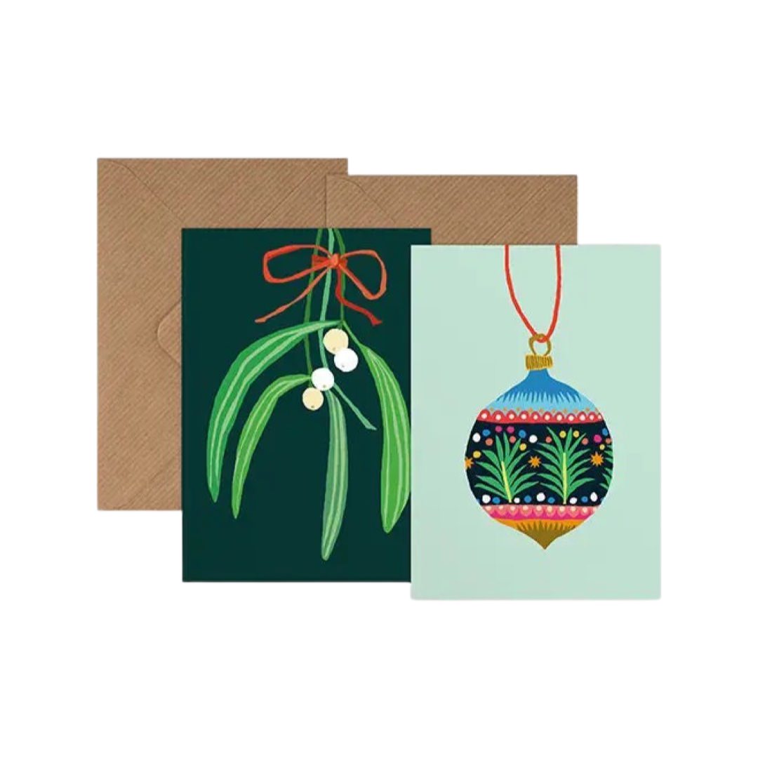 2 Christmas cards with brown envelopes, 1 with mistletoe on a green background and 1 with a colourful patterned Christmas bauble on a pale blue background.