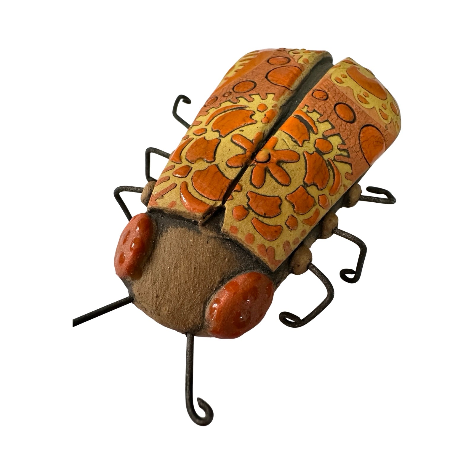 A long ceramic beetle in orange with orange and yellow flowers and orange spots and wire legs.