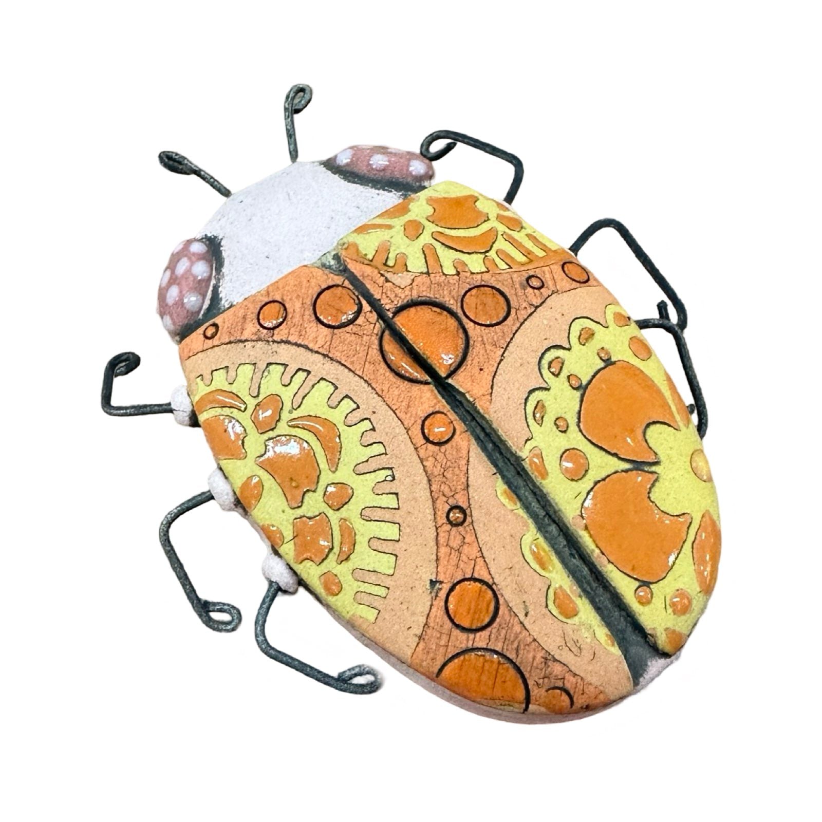 An oval ceramic beetle in orange with orange and yellow flowers and wire legs.