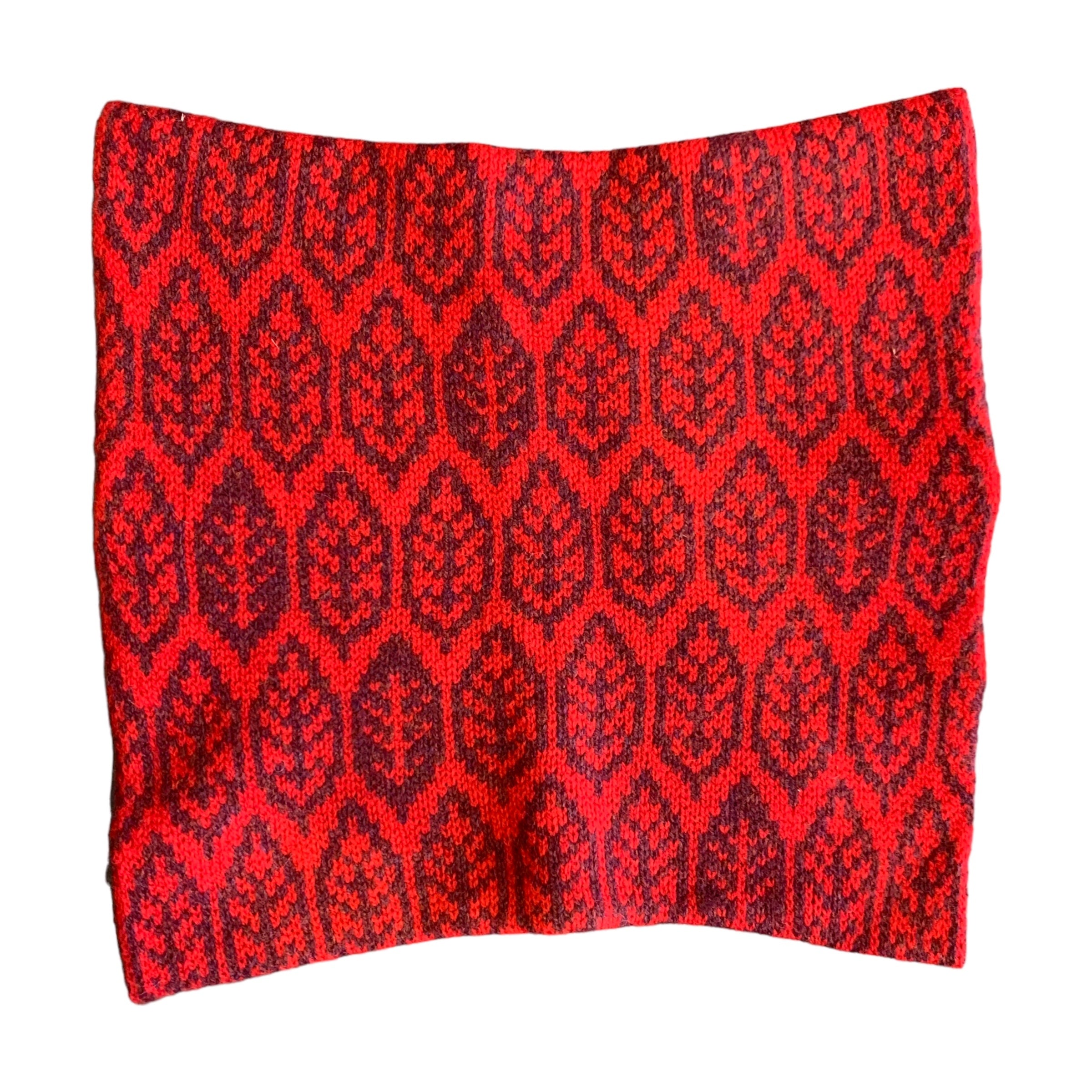 A super soft and cosy 100% lambswool knitted snood in a leaf design in shades of red.