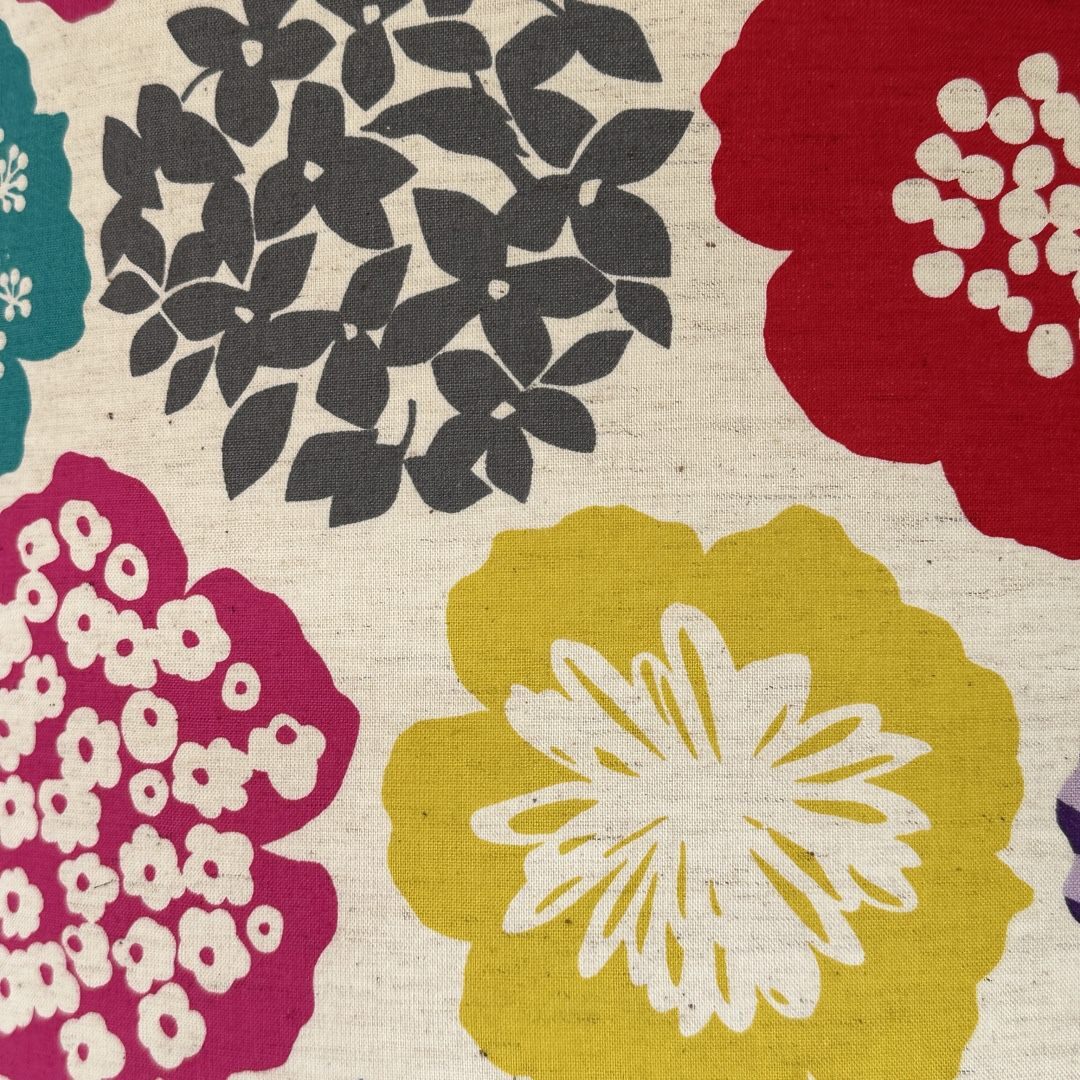 cream fabric with big red, grey, yellow, and pink flowers