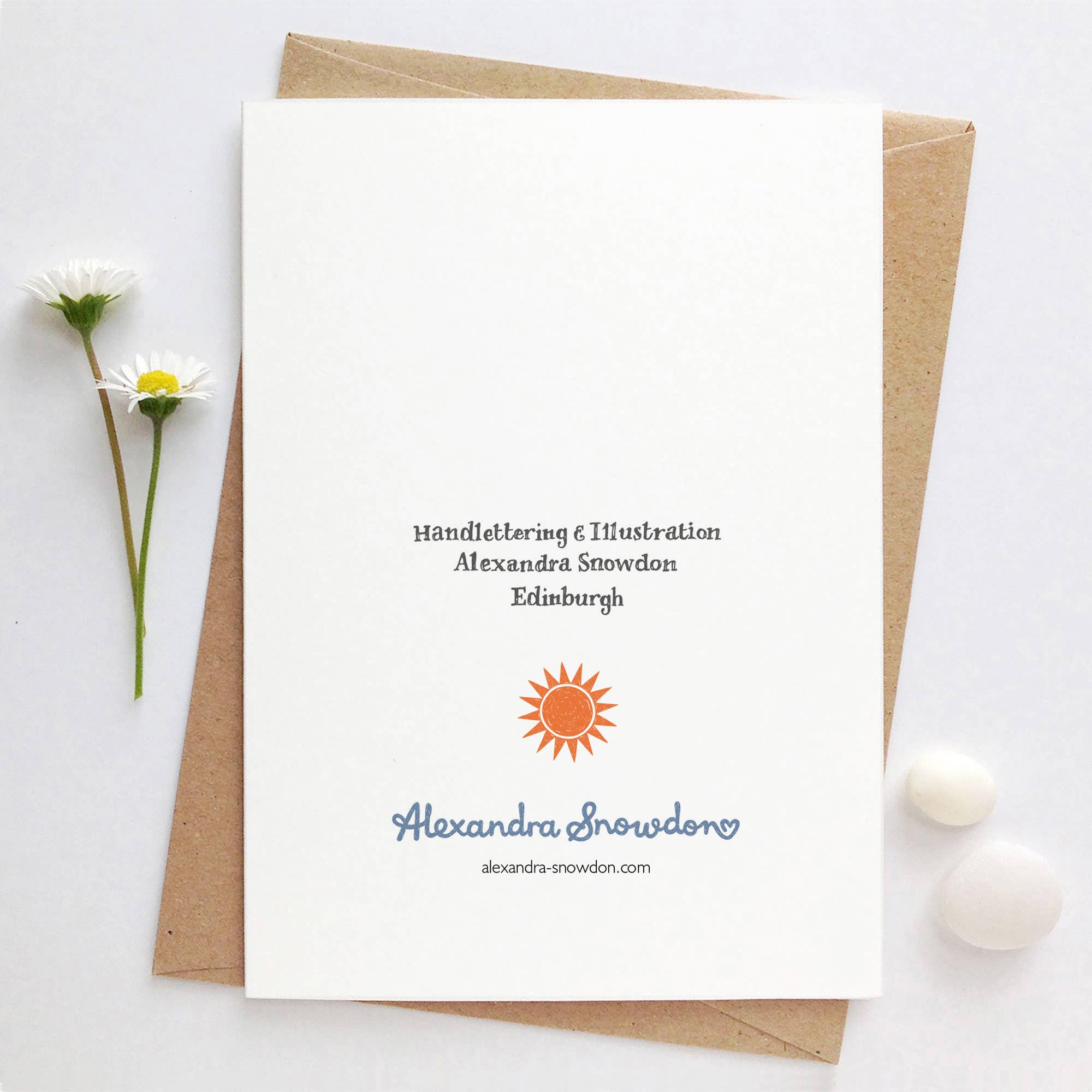 Greeting card with handlettering and illustration by Alexandra Snowdon, featuring a sun logo and two flowers.