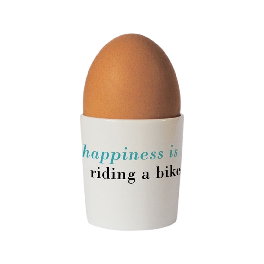 Cycling lovers bone china egg cup with the text 'happiness is riding a bike' written on the back.