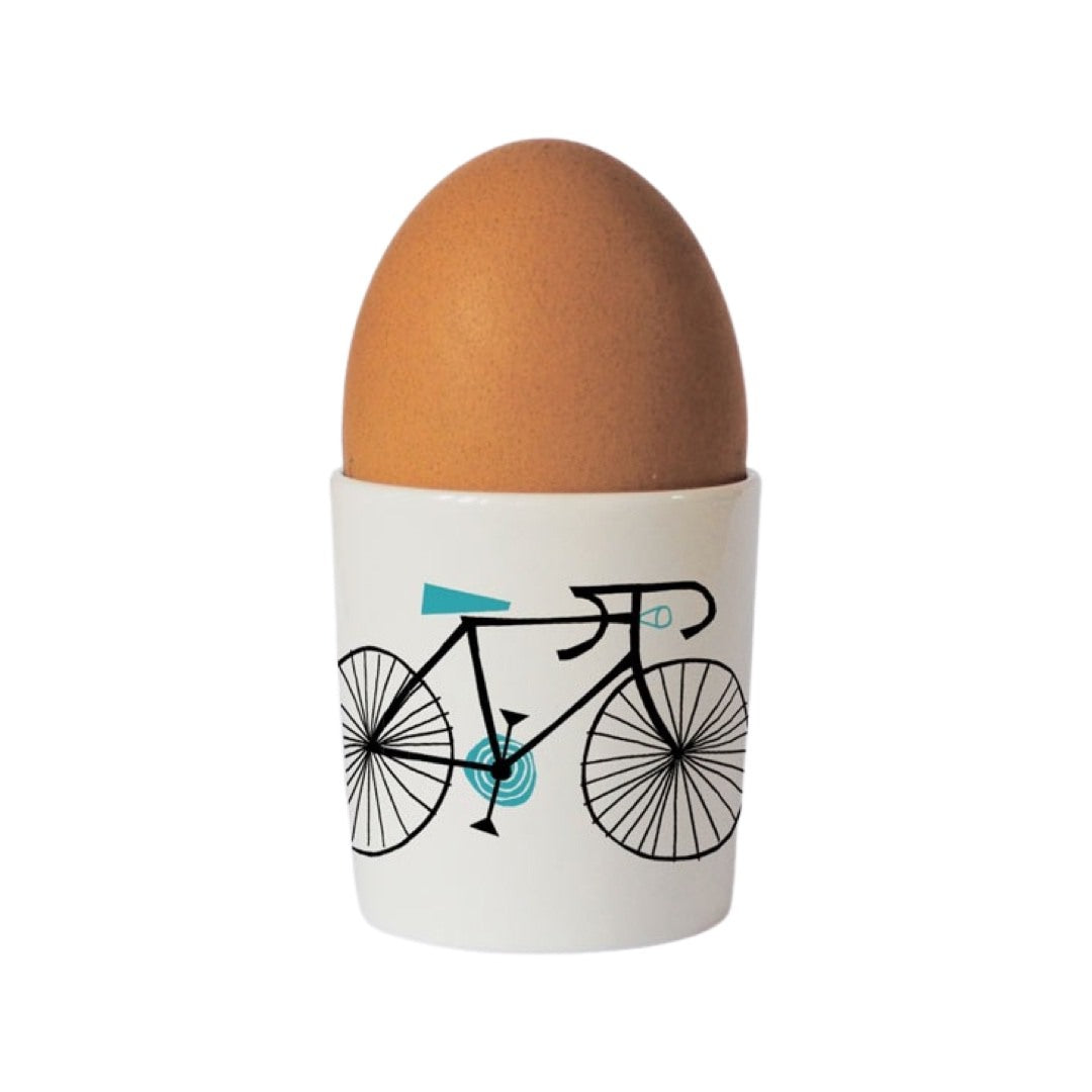 Cycling lovers bone china egg cup with an illustration of a black bicycle with a turquoise seat on the front.