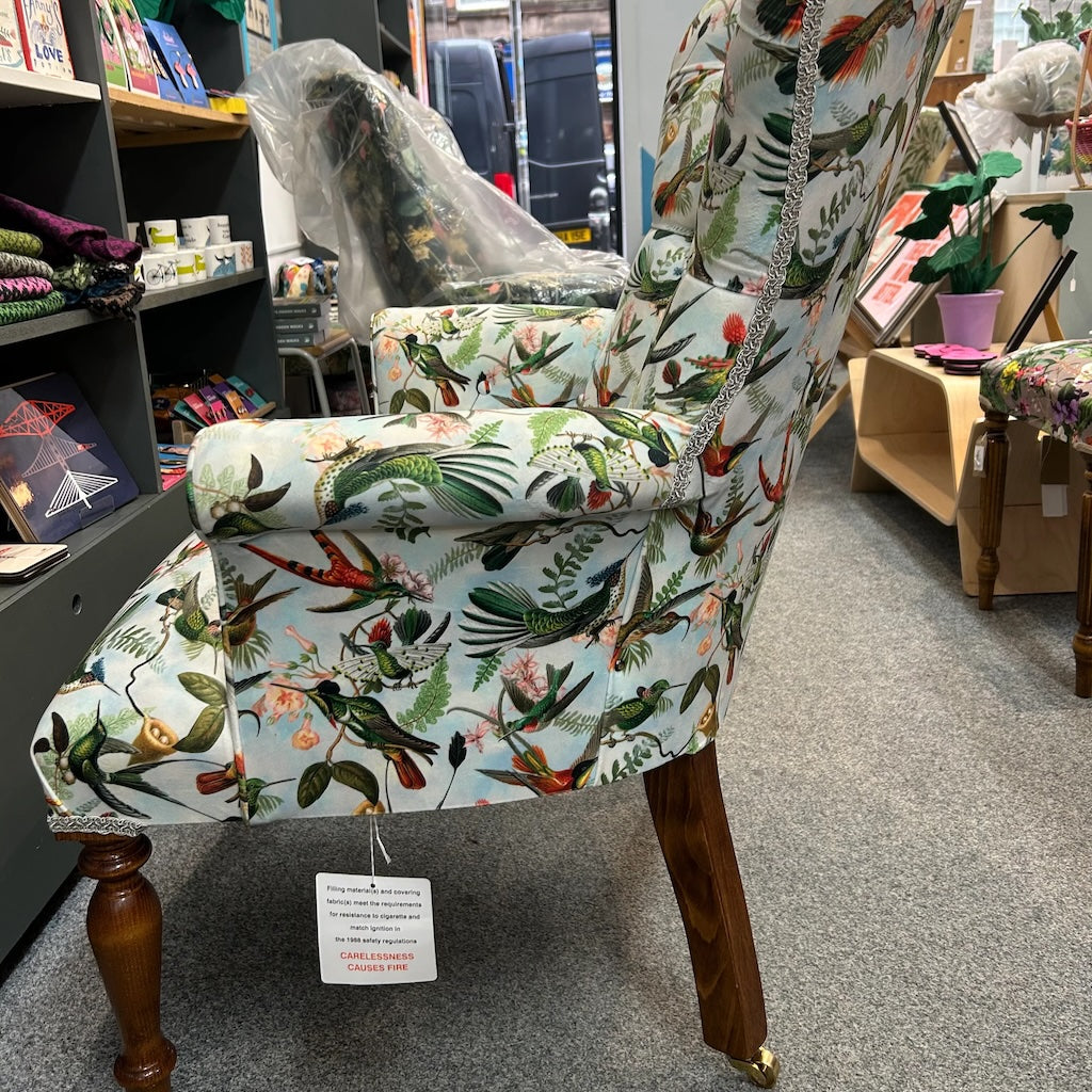Close-up of fabric with colourful bird and floral pattern.