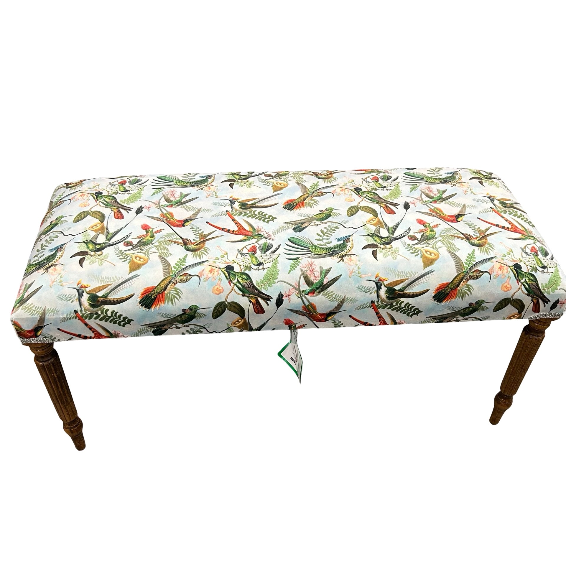 Bench with bird patterned cushion on a white background.