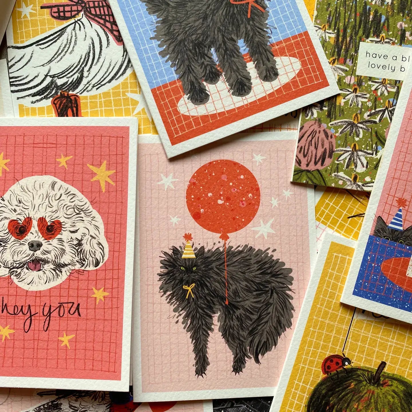 Collection of greeting cards with various designs featuring animals and abstract elements.