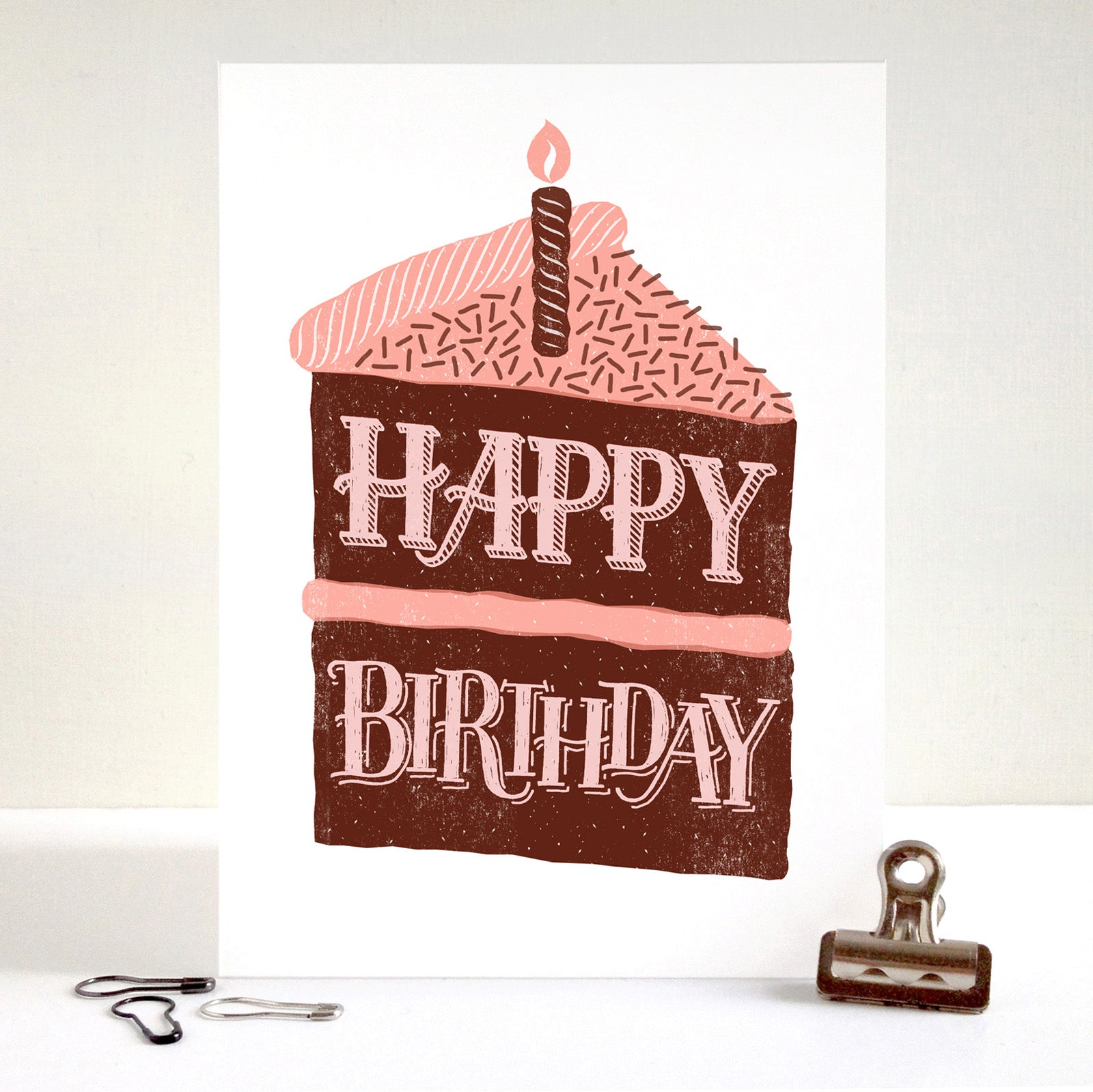 Birthday card with cake design and 'Happy Birthday' text on a white background.