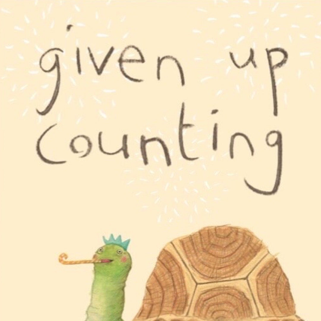 Birthday card with an illustration of a turtle with a kazoo in its mouth. A birthday cake with lots of candles sits next to the turtle. The card has the text 'Given up counting'.
