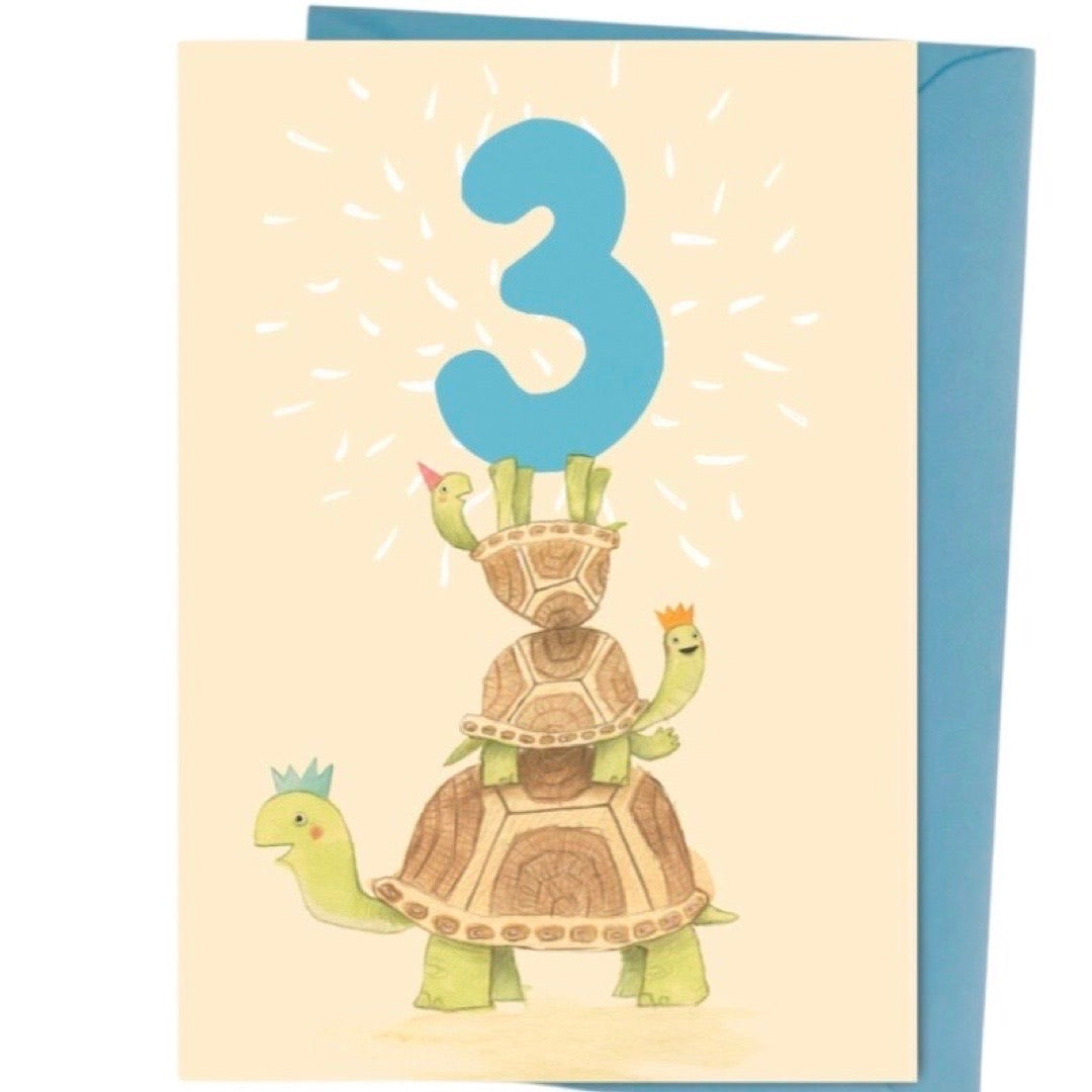 Birthday card with turtle design and number 3 balloon on a beige background.