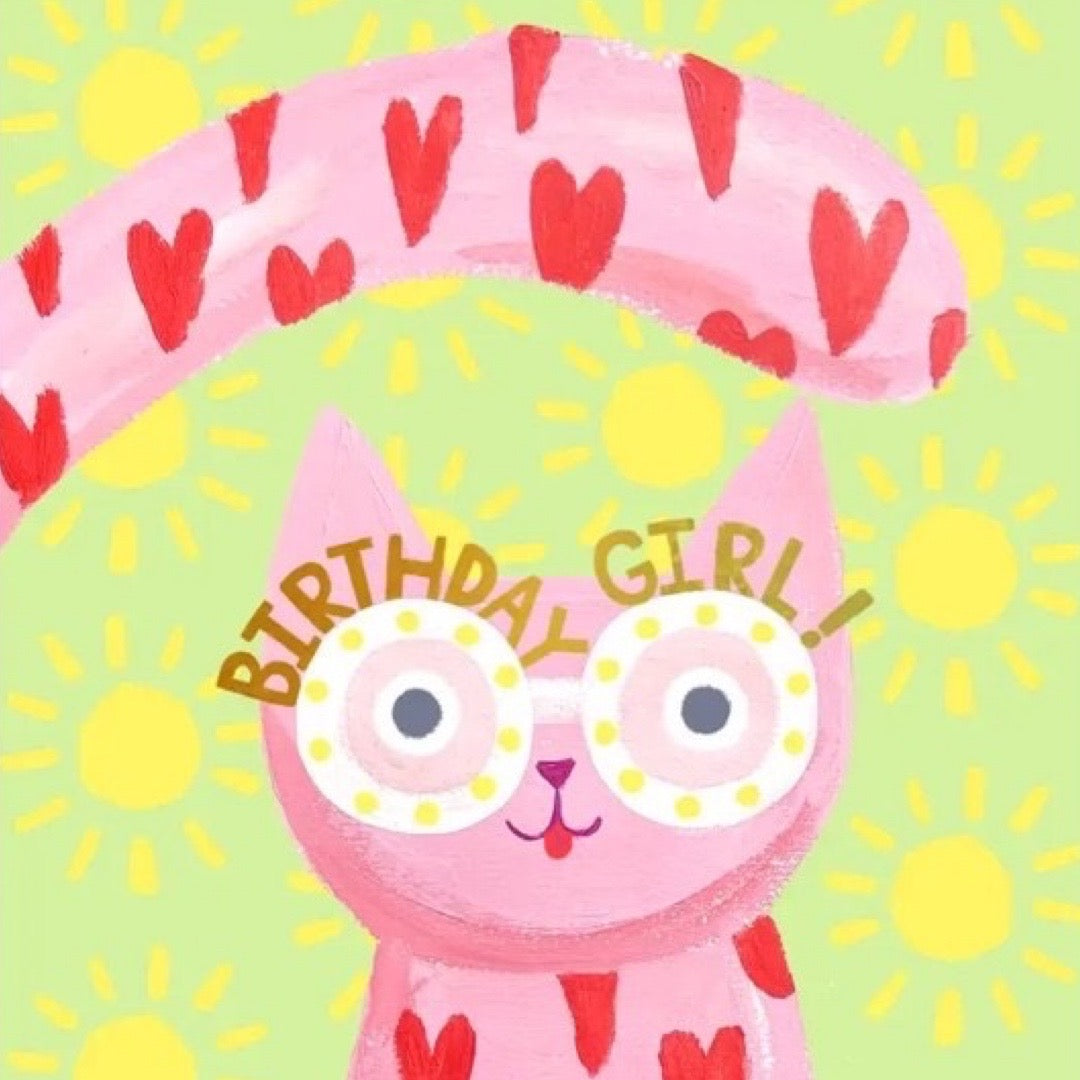 Pink cat with heart ears and tail with 'Birthday Girl!' text on a green background with yellow suns.