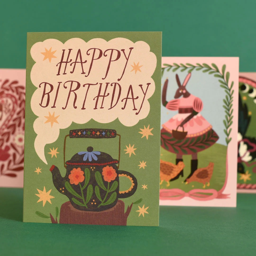 Birthday card with teapot design on a green background.