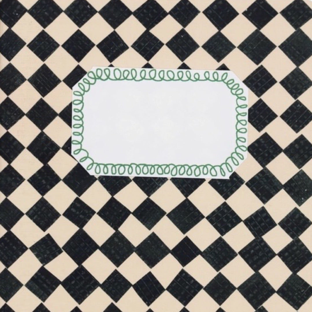 A square white label with an irregular rounded shape and a green scallop border, centered on a black and cream checkered background.