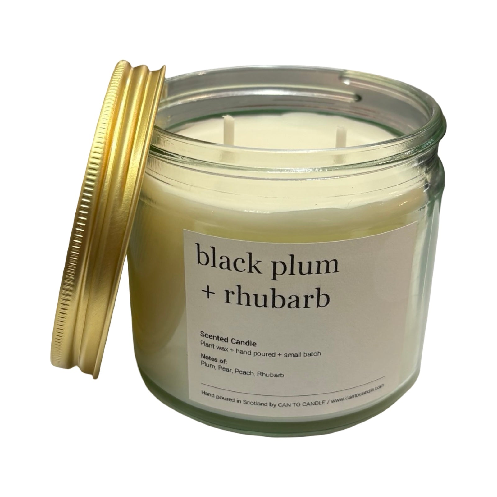 Candle jar labeled 'black plum + rhubarb' with a gold lid on a white background.