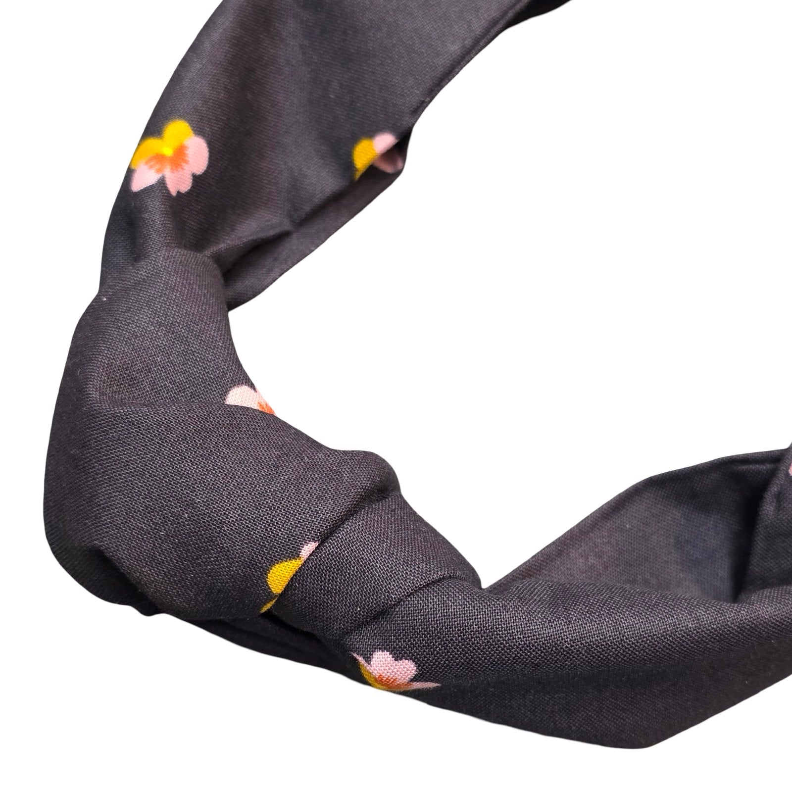 This black handmade floral top-knot Alice band is made from 100% cotton fabric with small mustard and pink violets. 