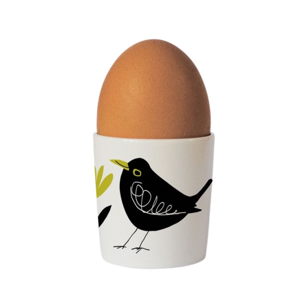 Bone china egg cup with an illustration of a blackbird with a green beak on the front.