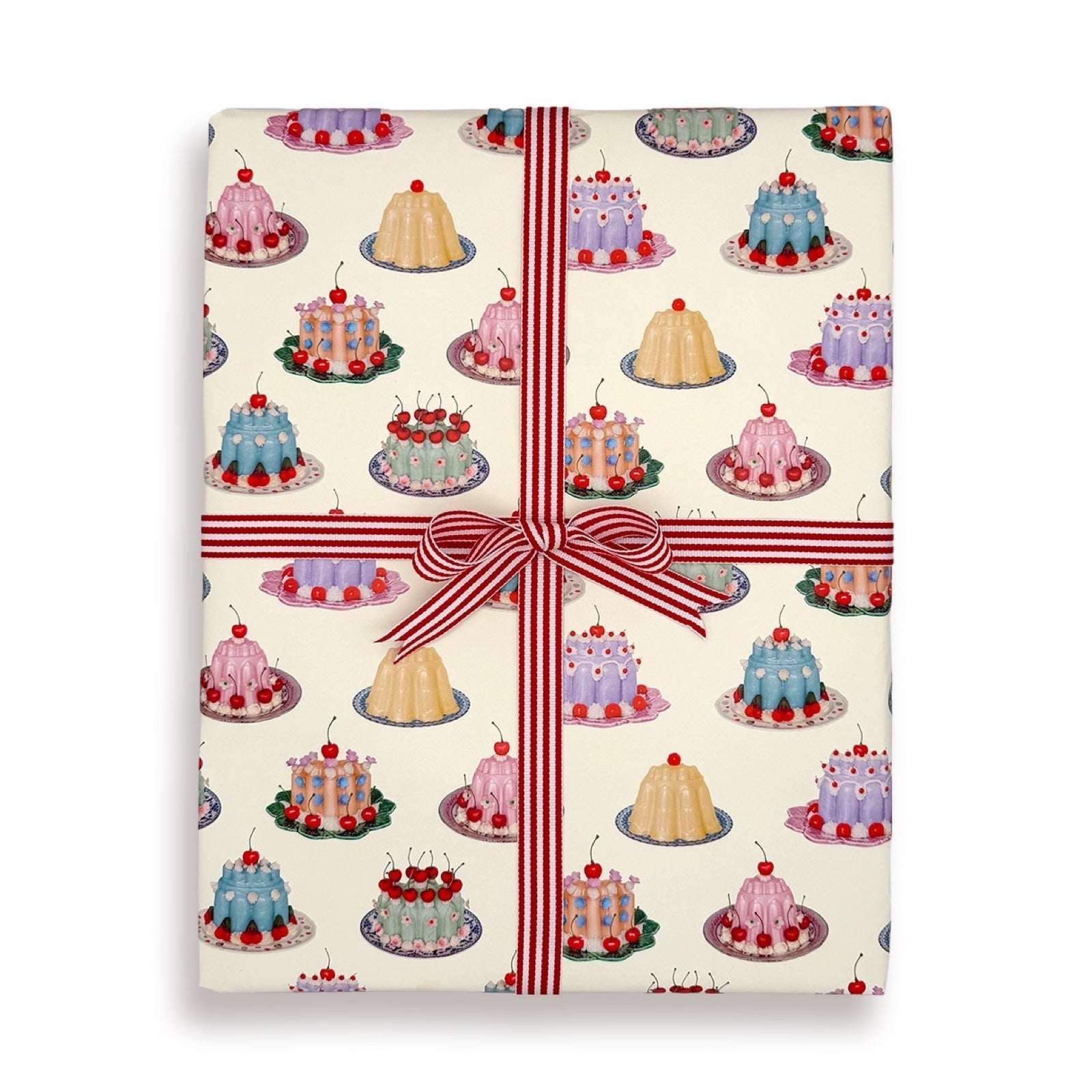 Gift wrapped present with cake pattern and red ribbon on a white background.