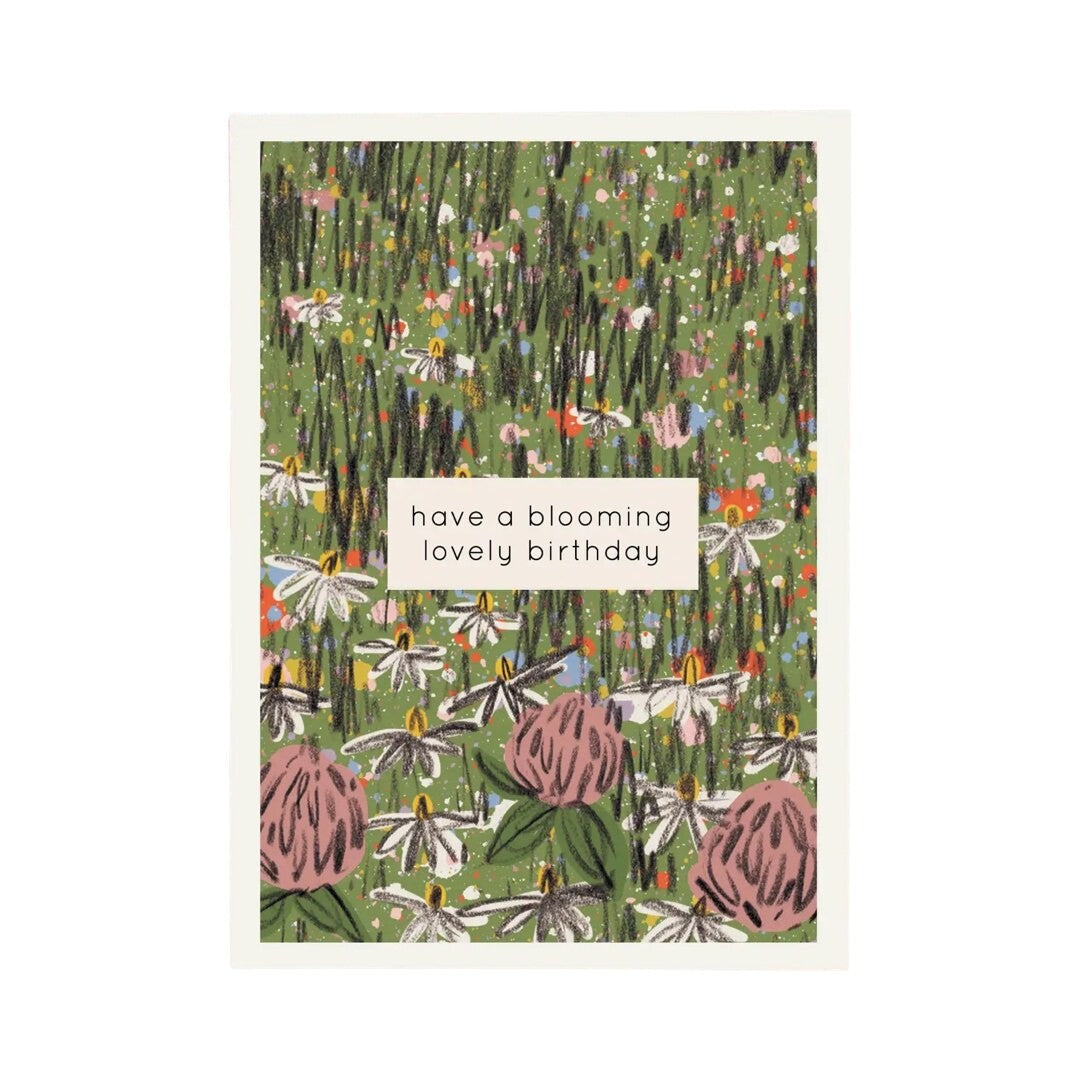 Birthday card featuring a hand-drawn spring meadow with colourful wildflowers and the text 'have a blooming lovely birthday' in a white box in the centre