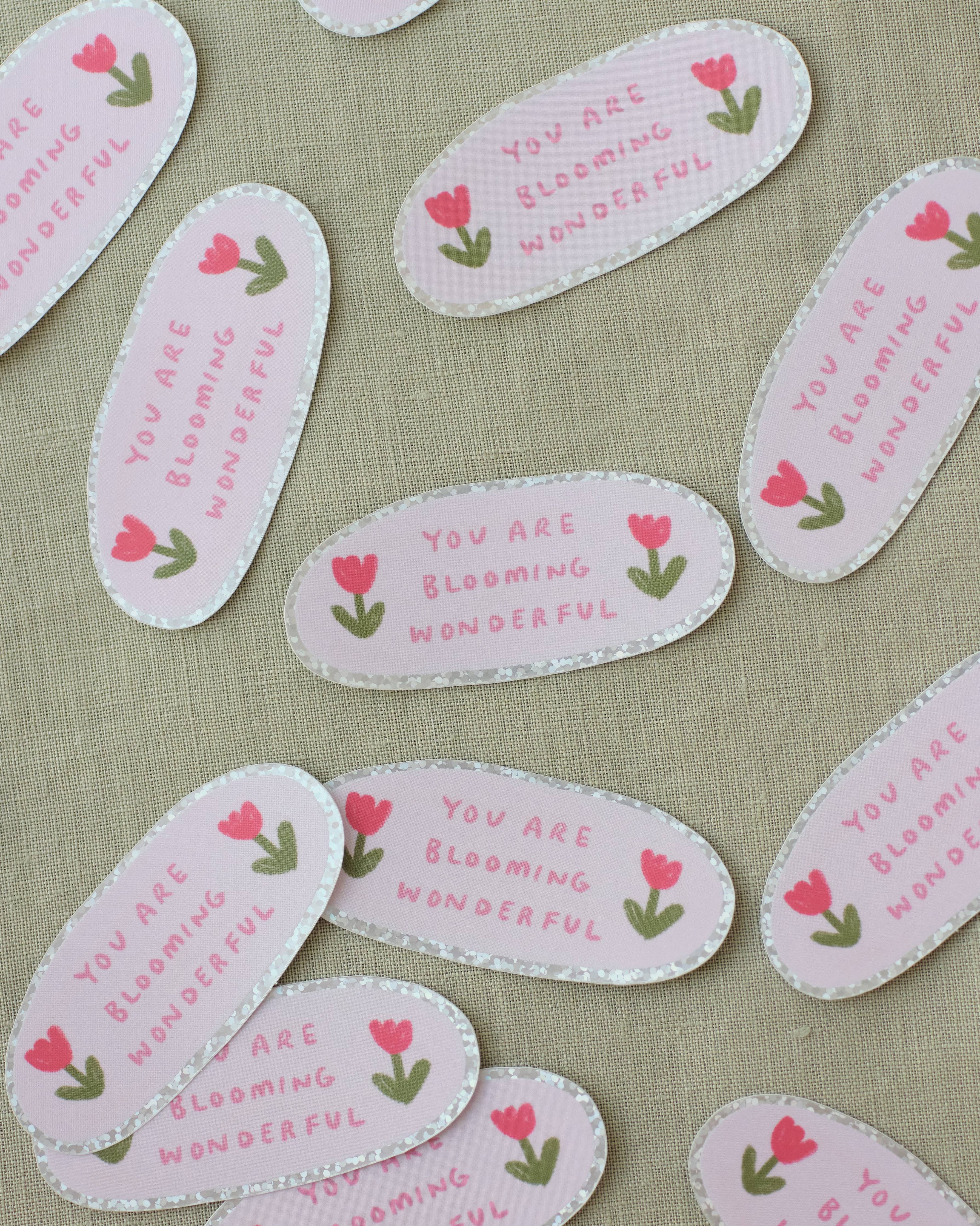 Decorative stickers with tulip illustrations and text on a fabric background.