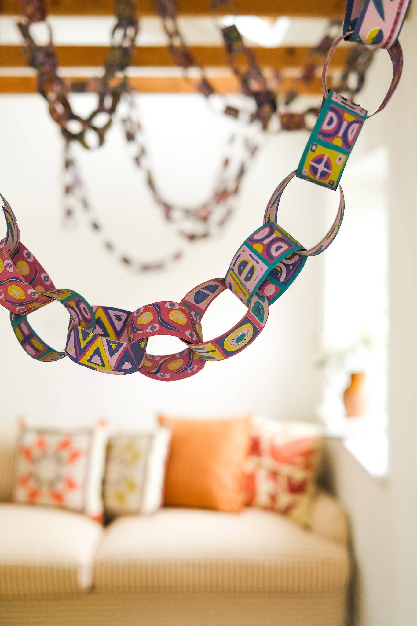 Colourful chain hanging from the ceiling with a blurred living room background