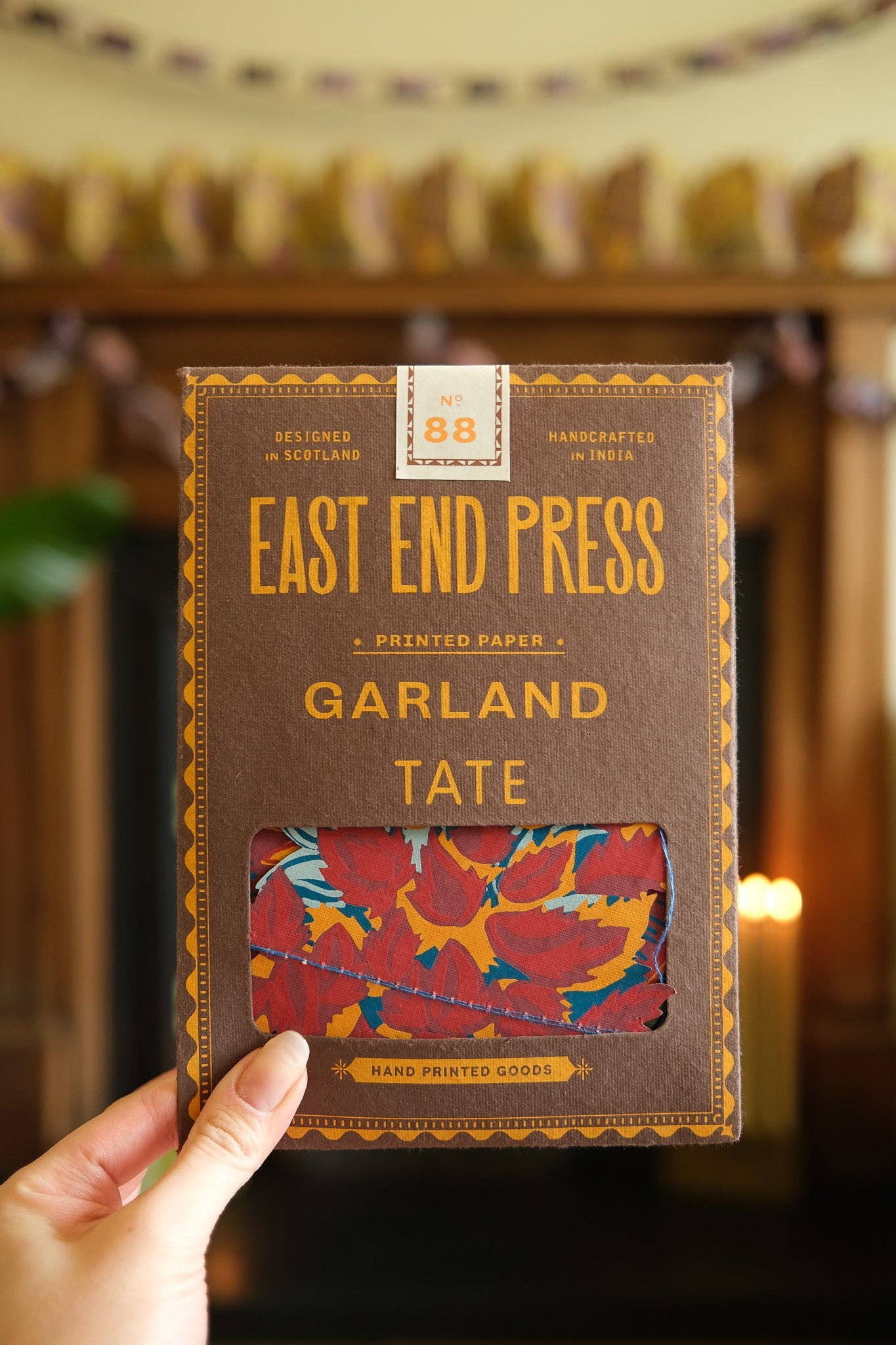 Packaged product from East End Press held by a hand with a blurred background.