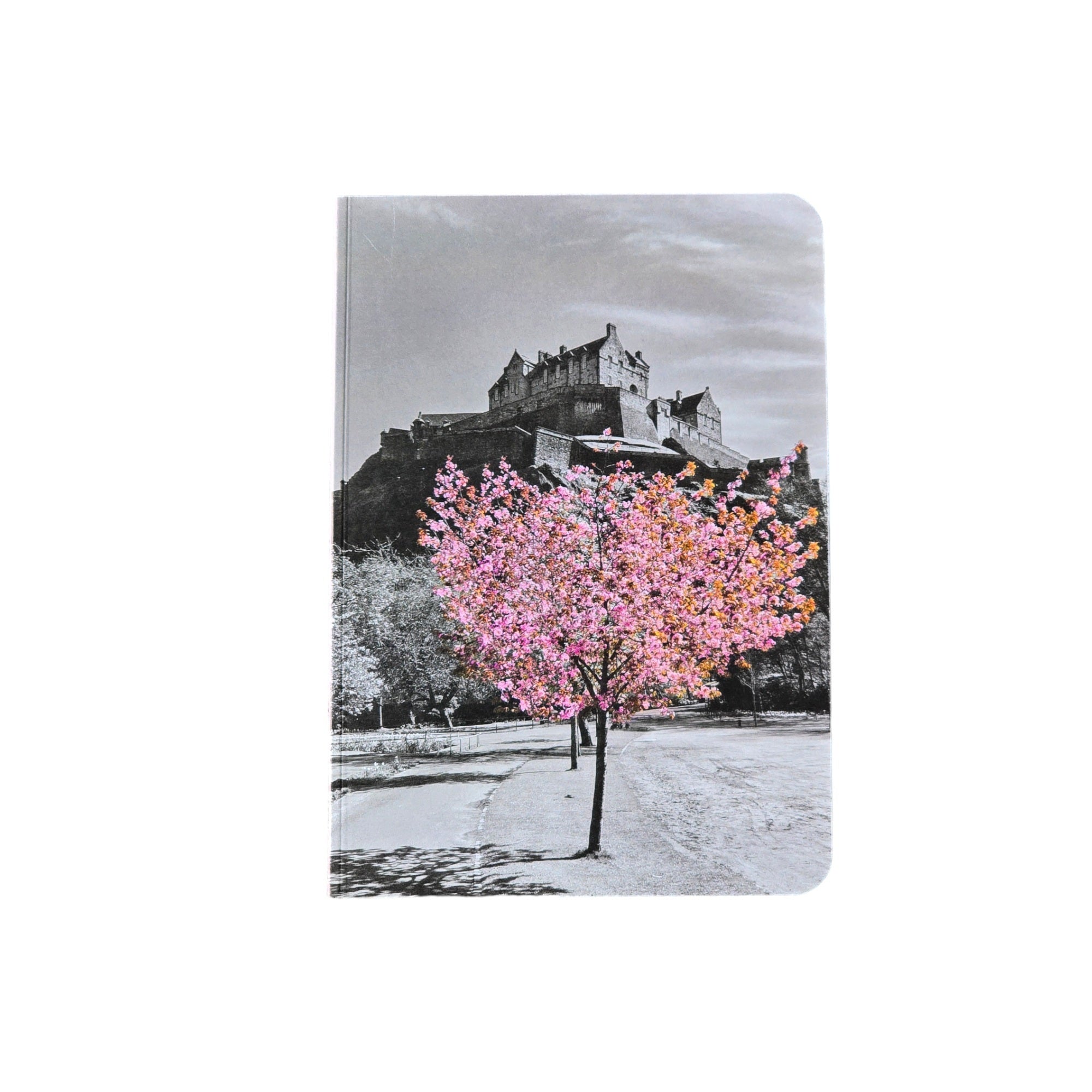 A notebook with an image of Edinburgh Castle in black and white with a tree with pink blossom in the foreground on the cover of a notepad. 