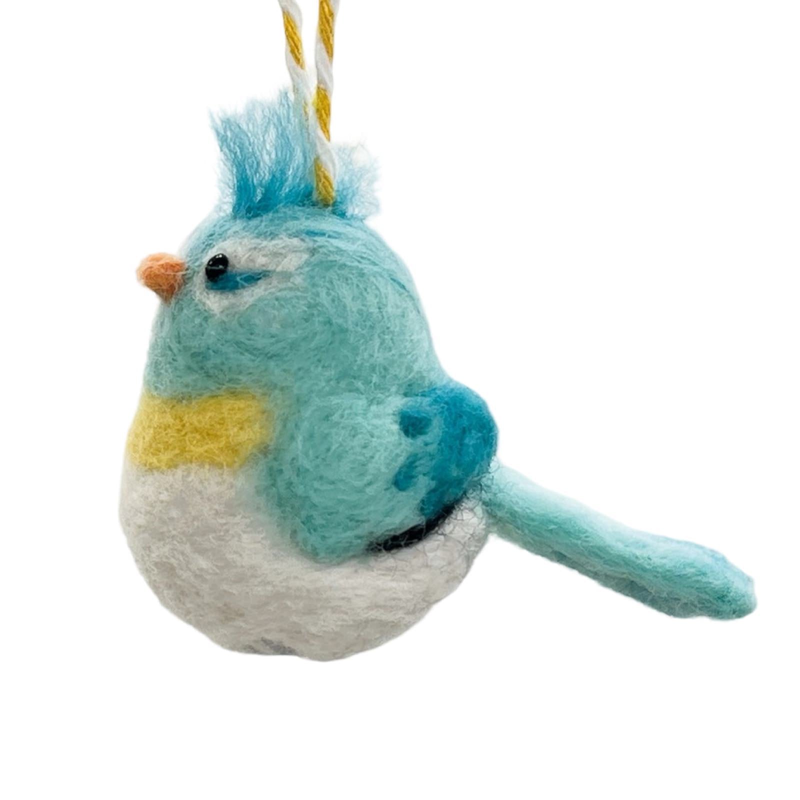 A blue and white felted baby bird hanging on a yellow and white string