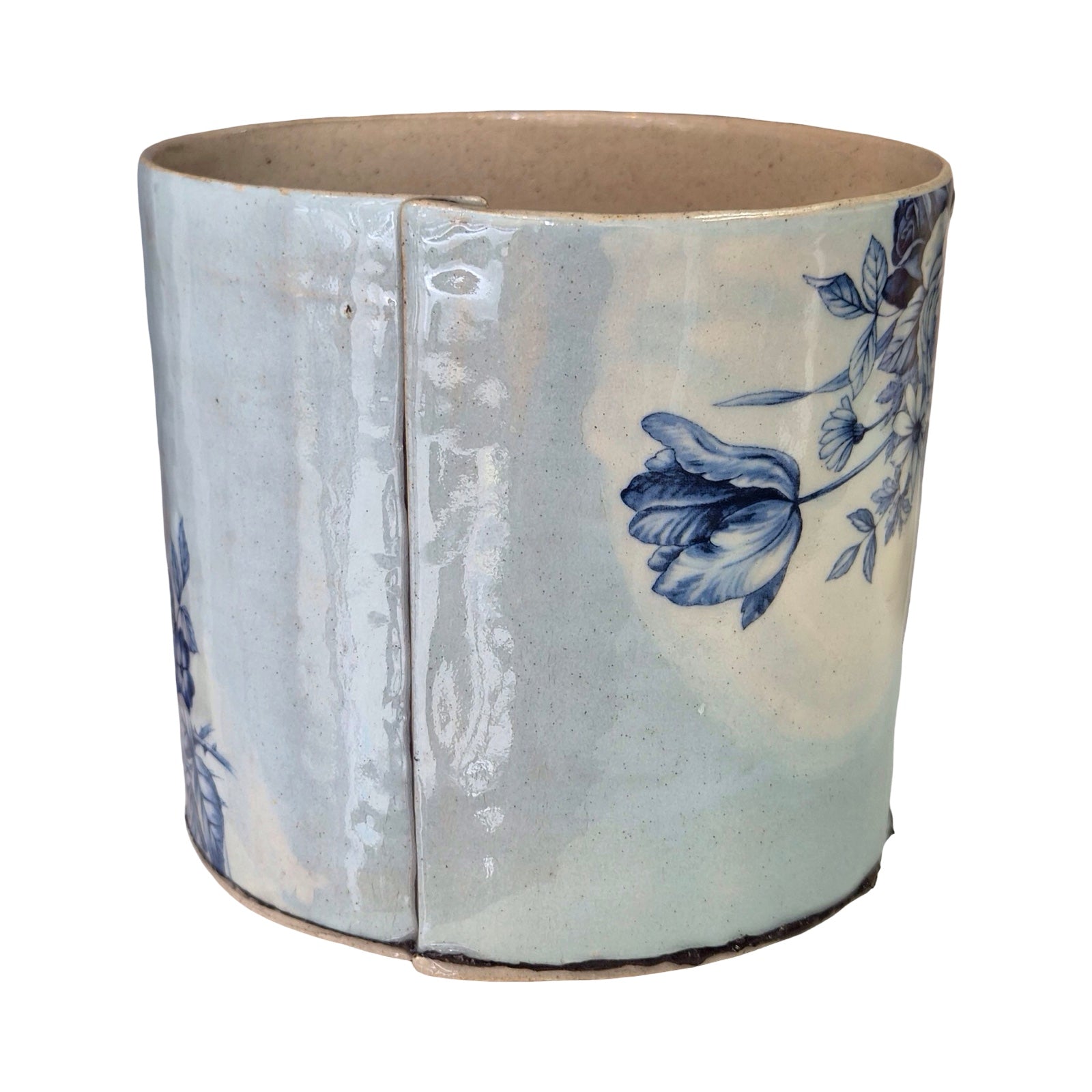 Ceramic planter with blue floral design on a white background.